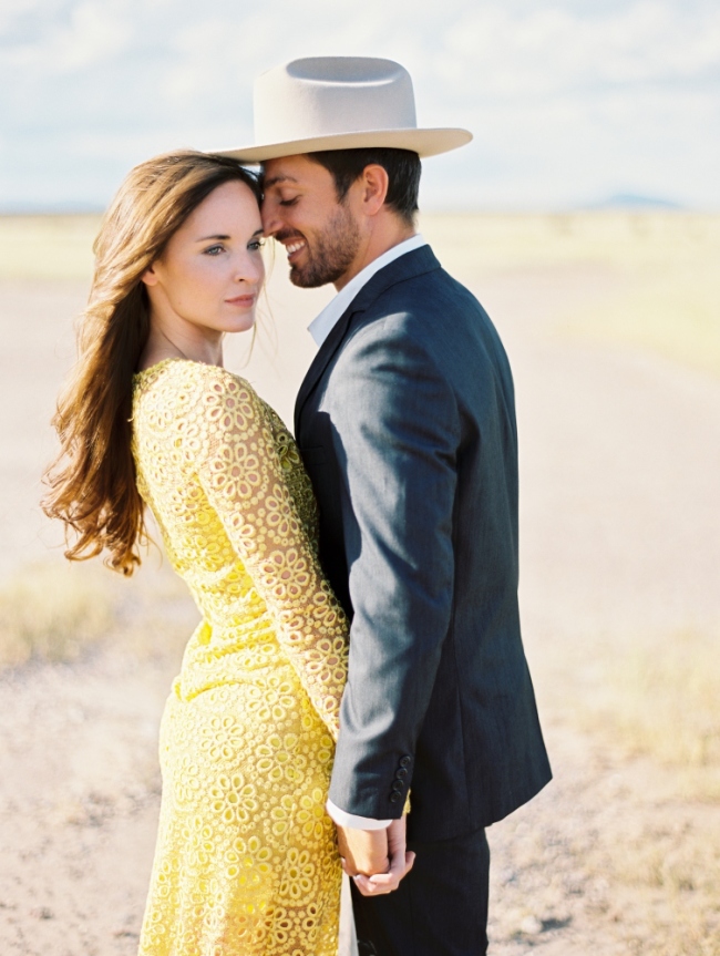 marfa elopement girl in yellow dress man in suit and stetson holding hands