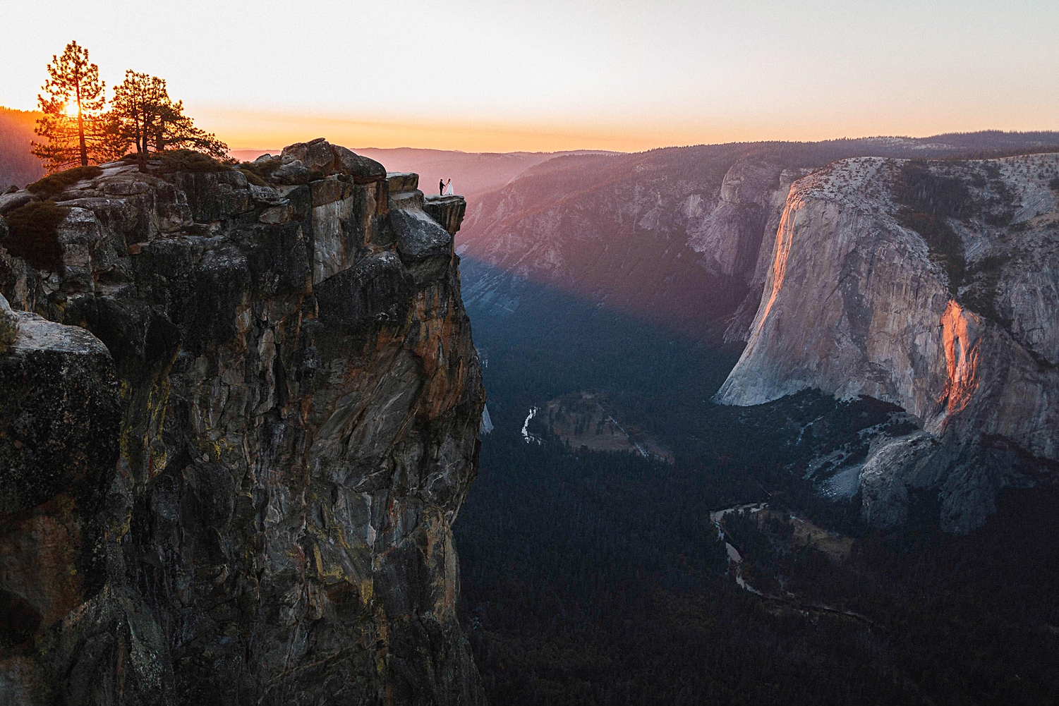 Bride and Groom On cliff over Yosemite Valley at sunset elopement wedding