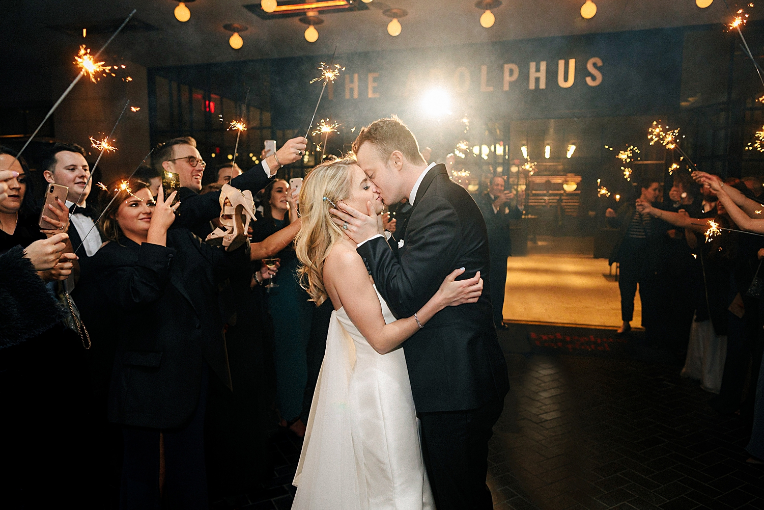 bride and groom kissing sparkler exit in front of hotel entrance Adolphus wedding Venue