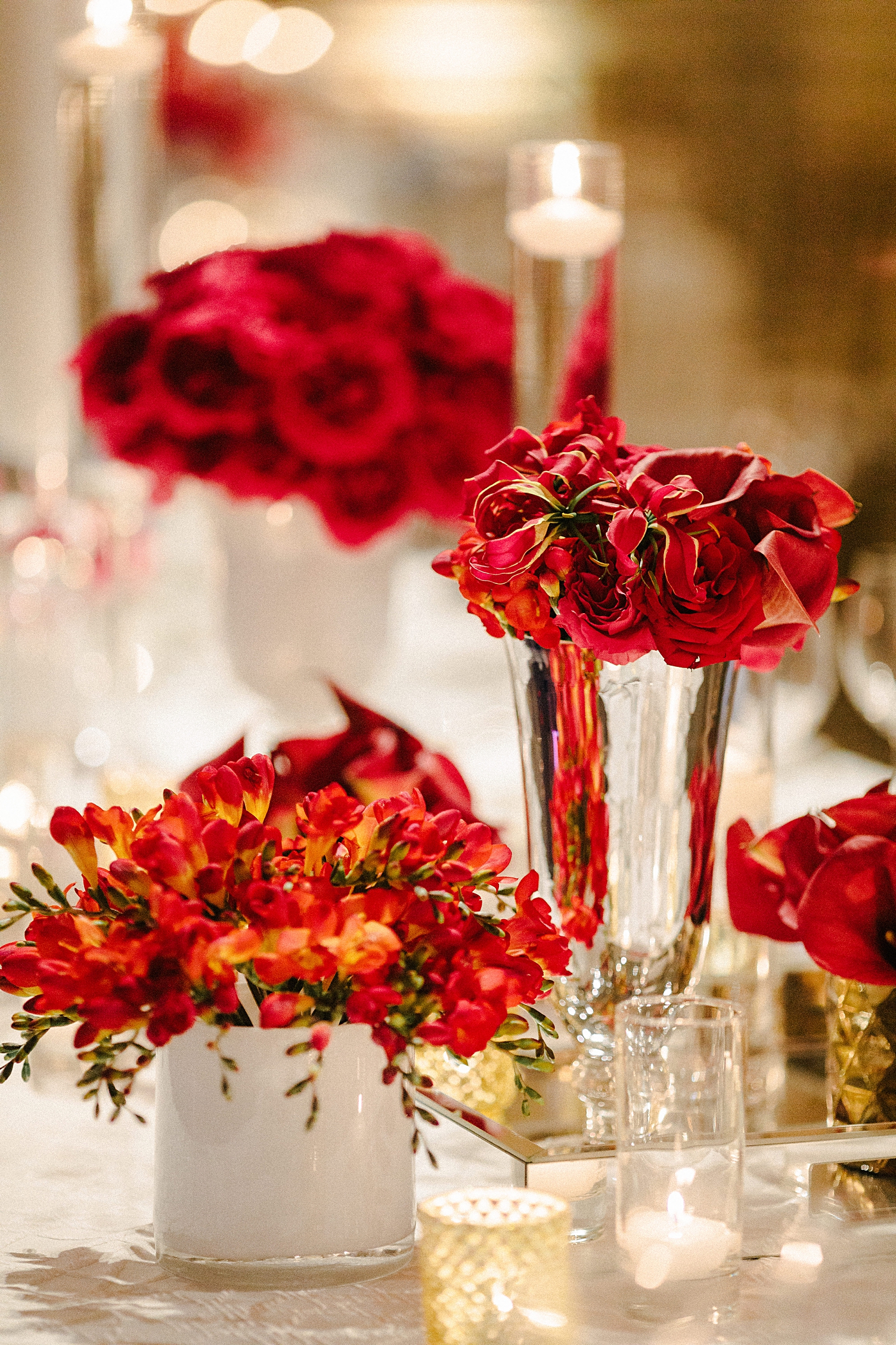 wedding reception table red flowers gold vases