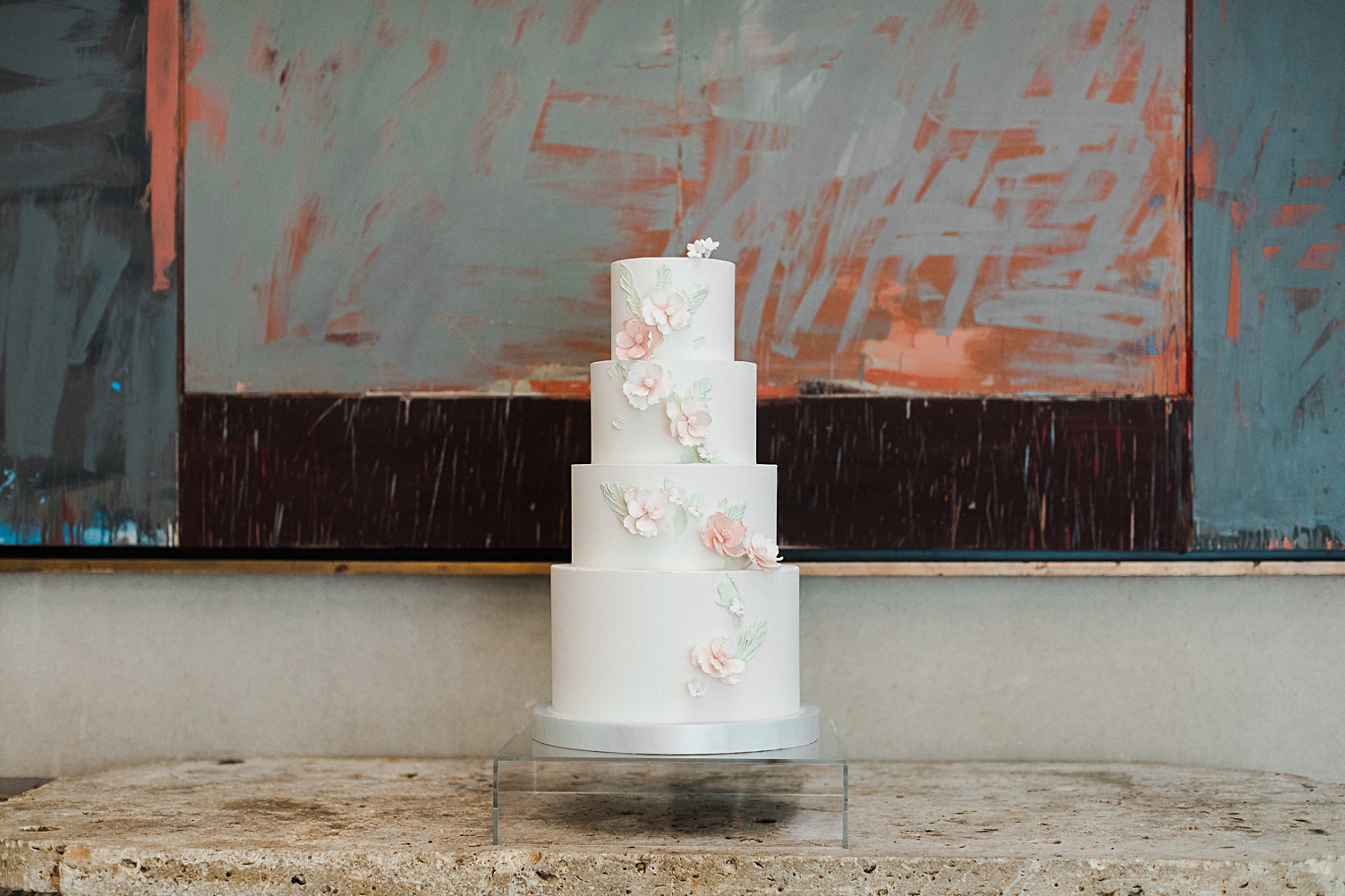 White four tiered wedding cake with pink flowers