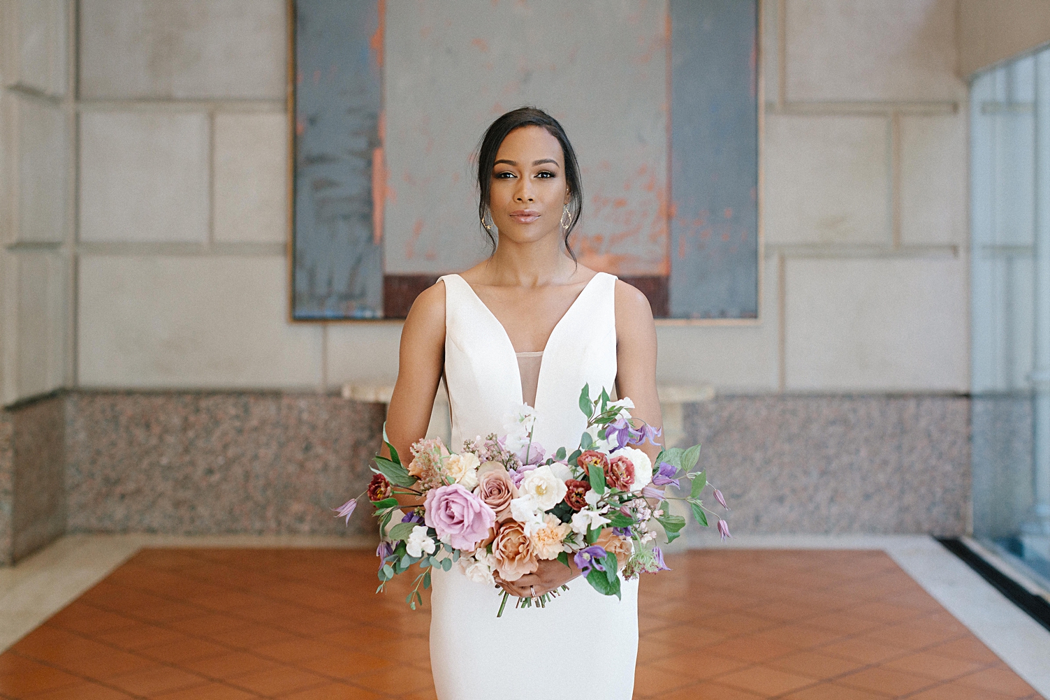 Bride in modern wedding dress holding bouquet