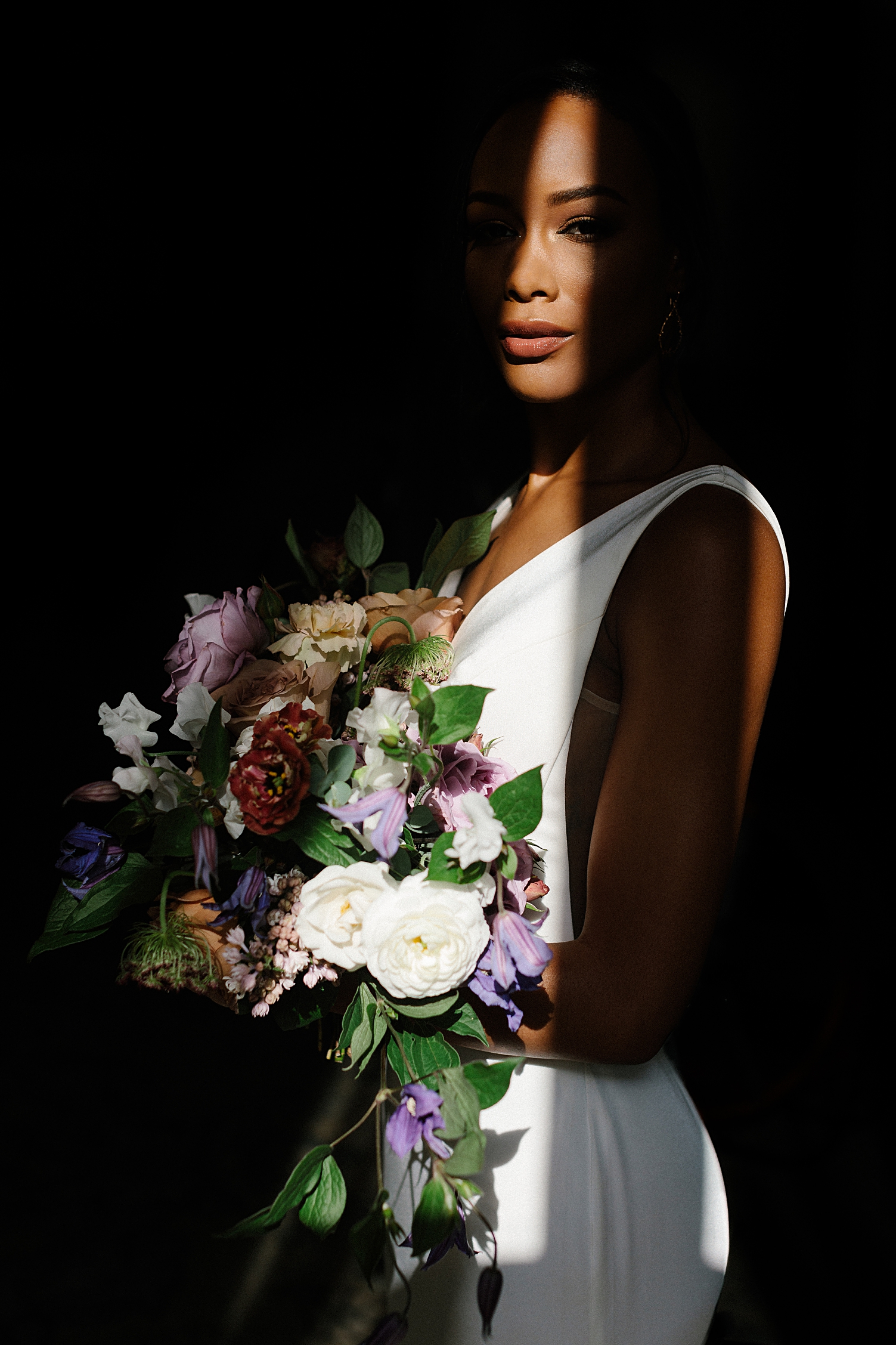 black bride with bouquet in dark room