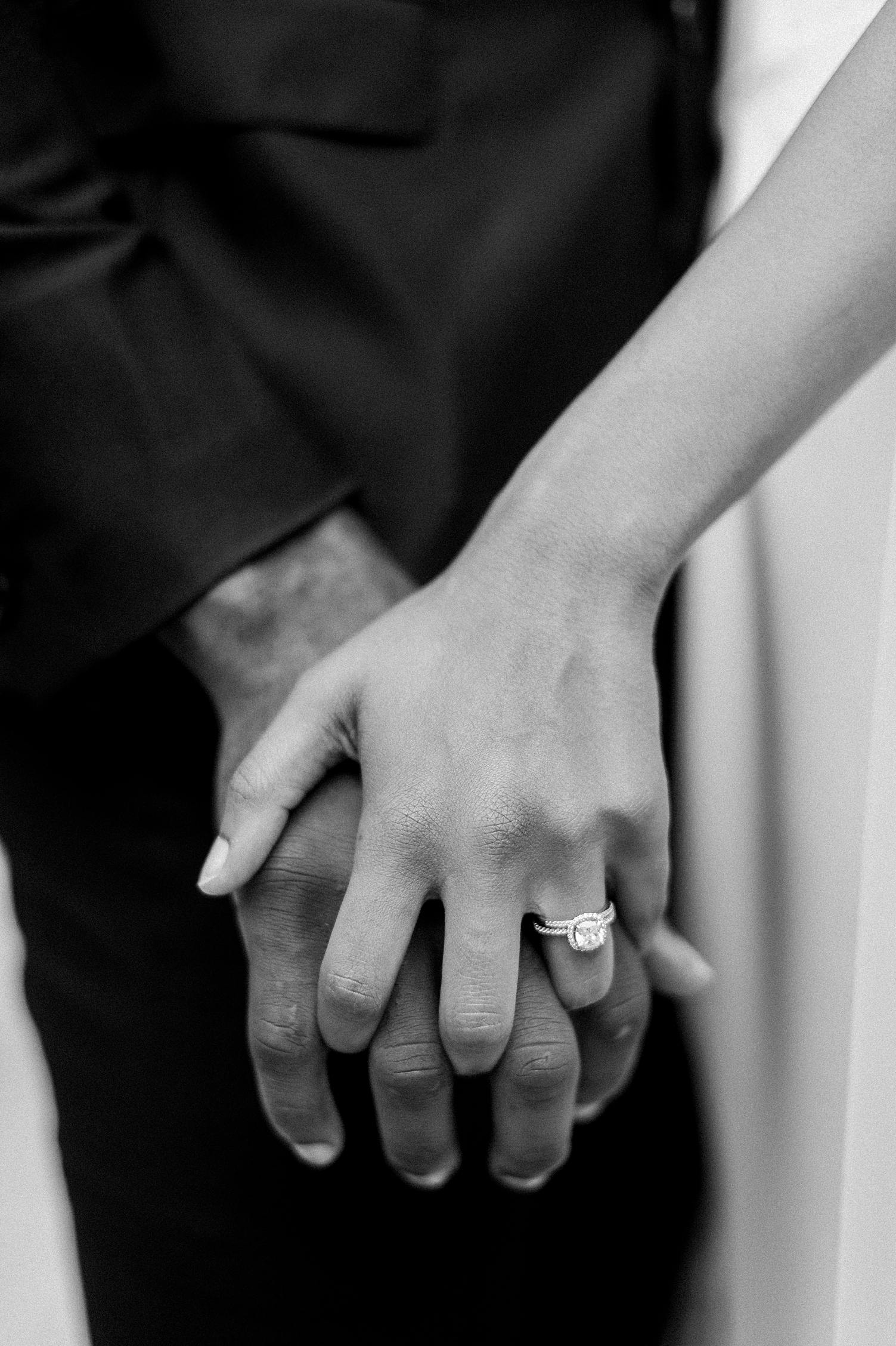 black and white hands with engagement ring