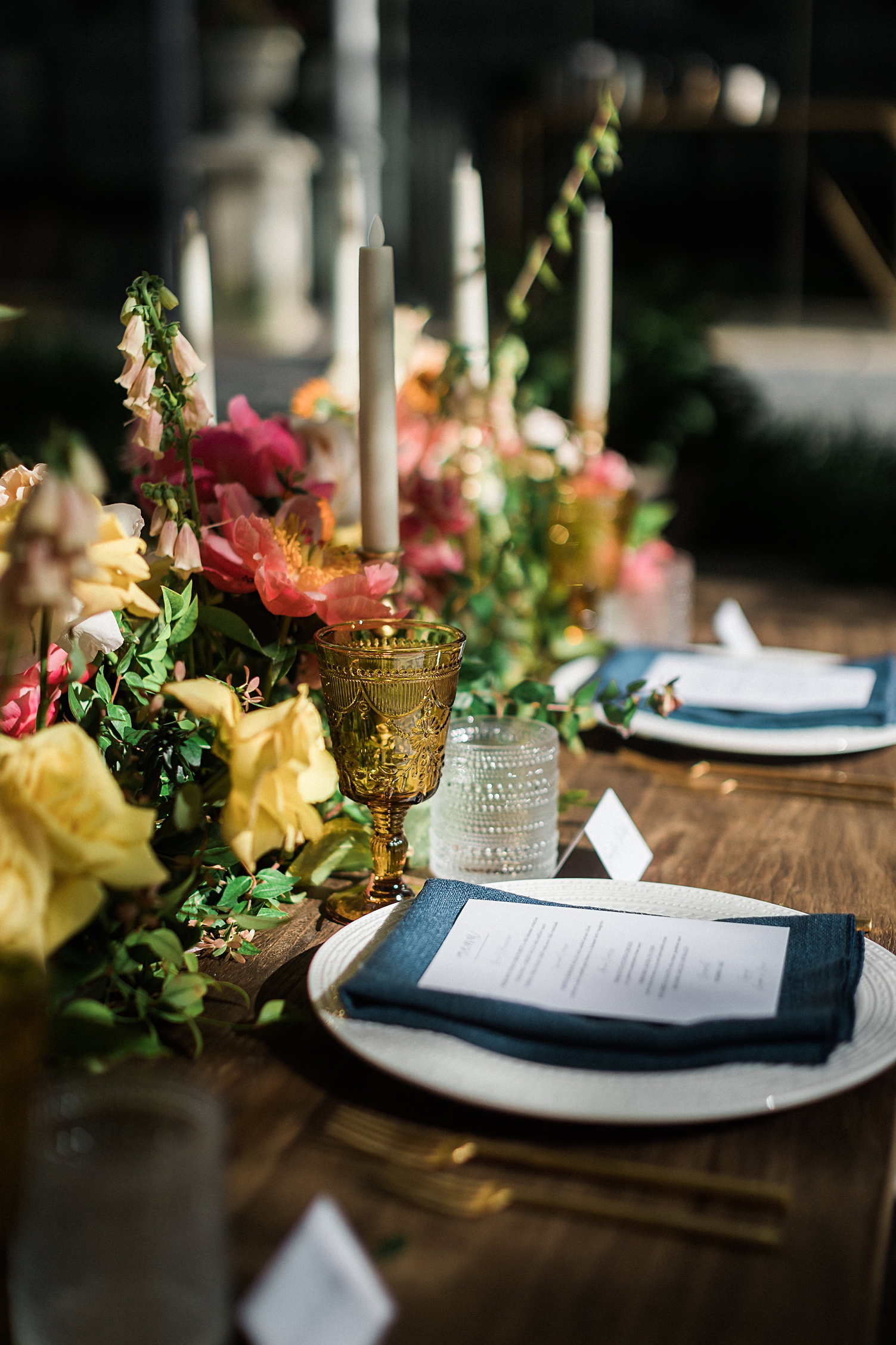 Outdoor garden wedding reception table with pink flowers and blue linens