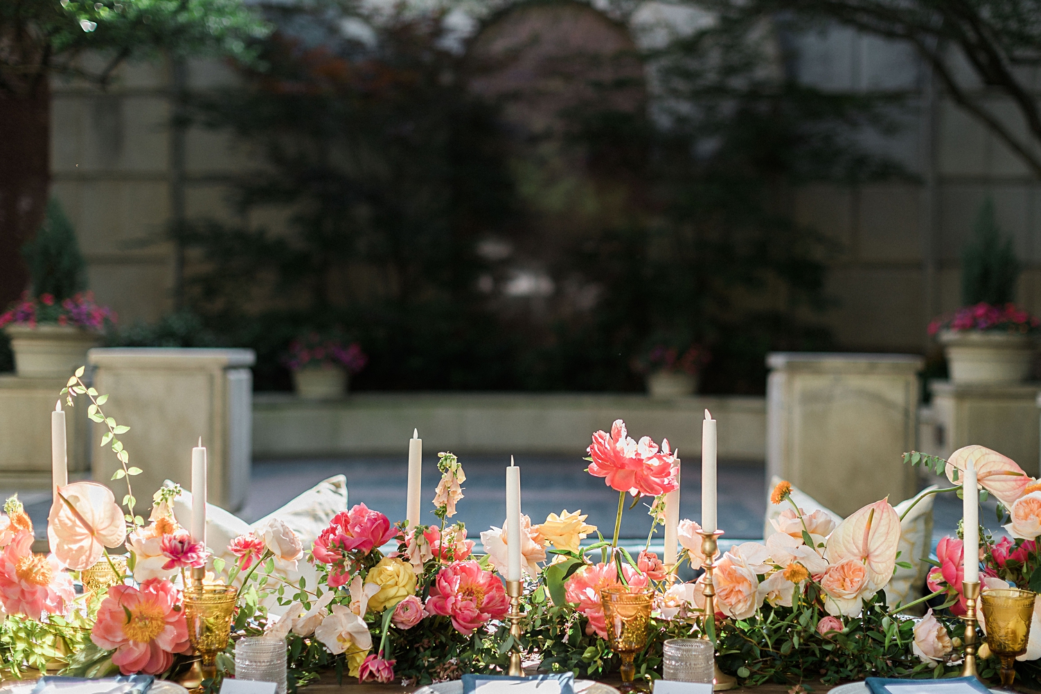 Outdoor garden wedding reception table with pink flowers and candles
