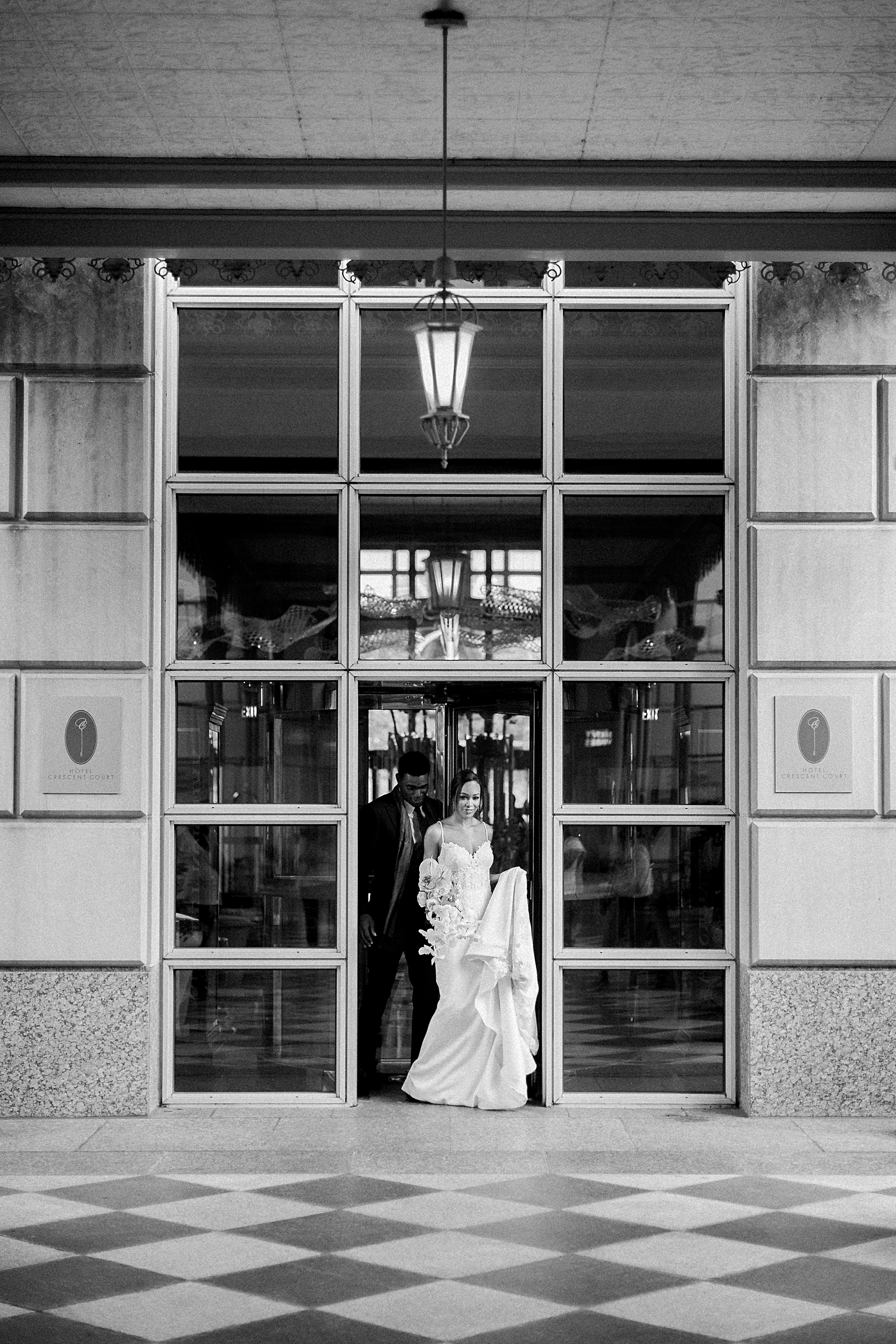black and white bride and groom coming out of revolving door crescent hotel wedding