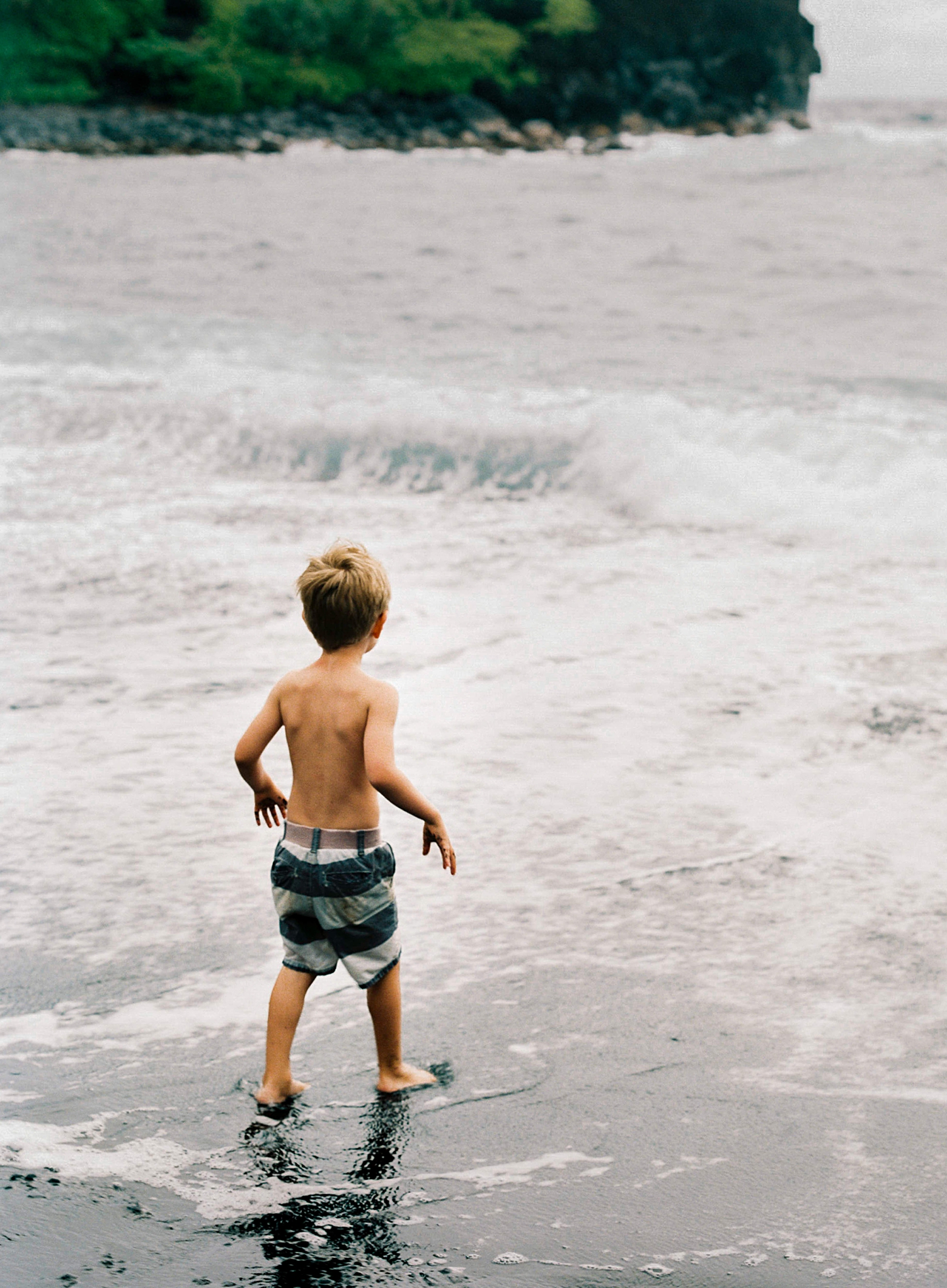 child on Honokalani black sand beach Maui Hana