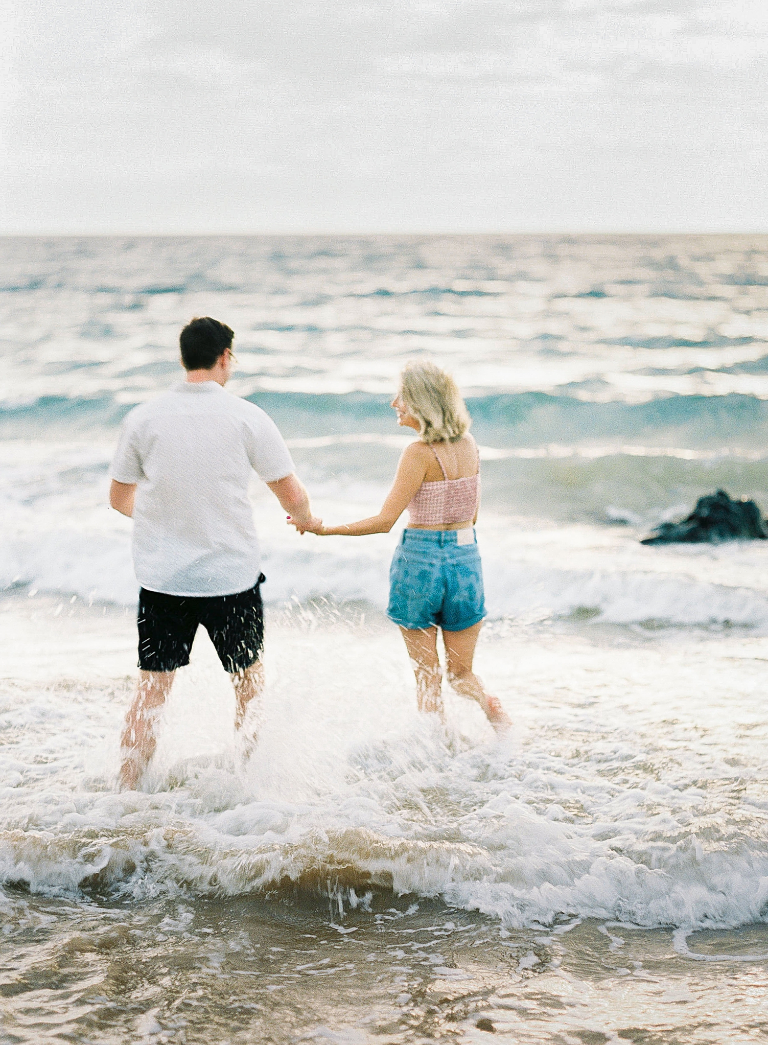 Wailea Maui engagement couple holding hands on beach Andaz 