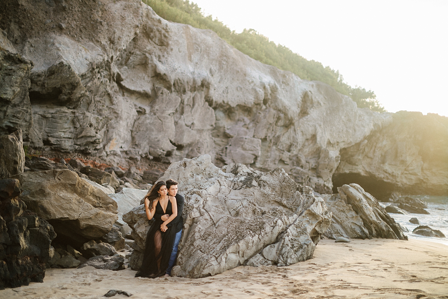 Maui beach engagement session couple leaning on rock