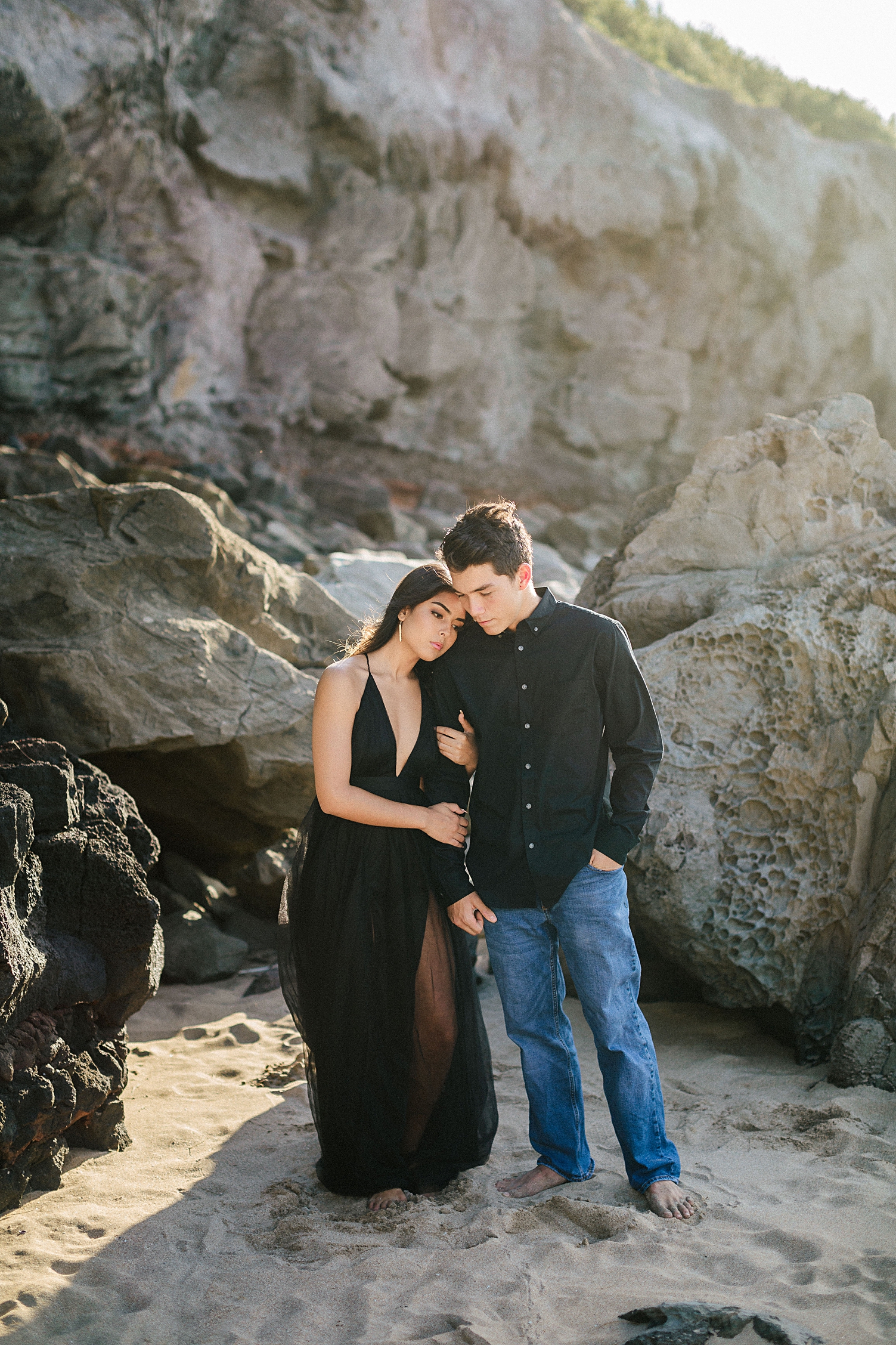 Maui engagement couple on beach black dress rocks