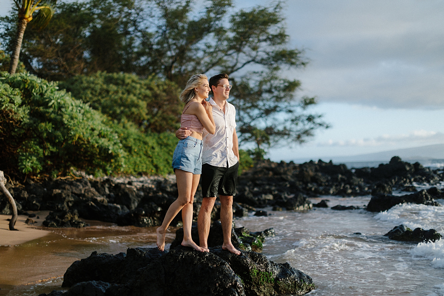 girl and man standing on black rock wailea beach hawaii