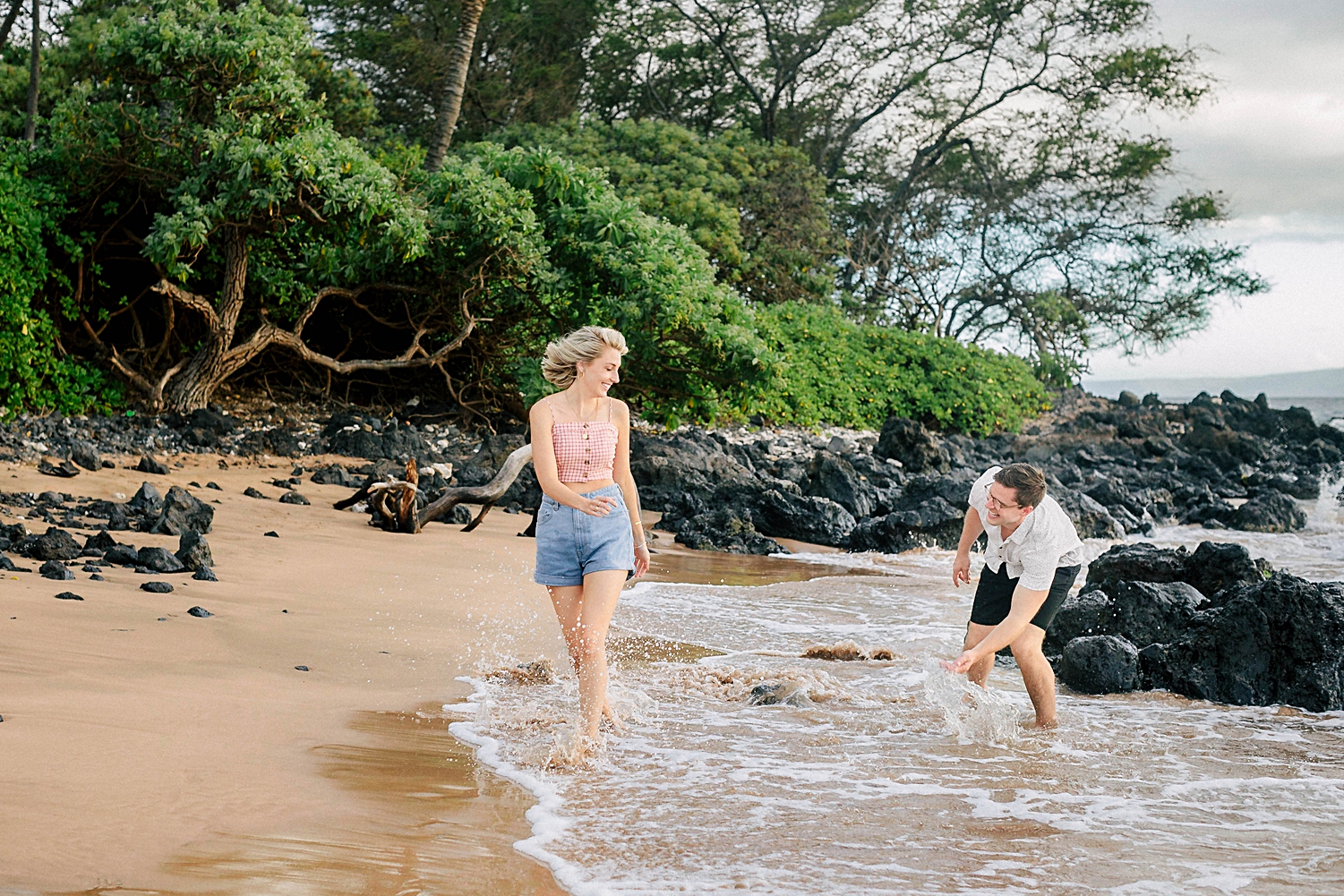 couple running and splashing on wailea beach Hawaii