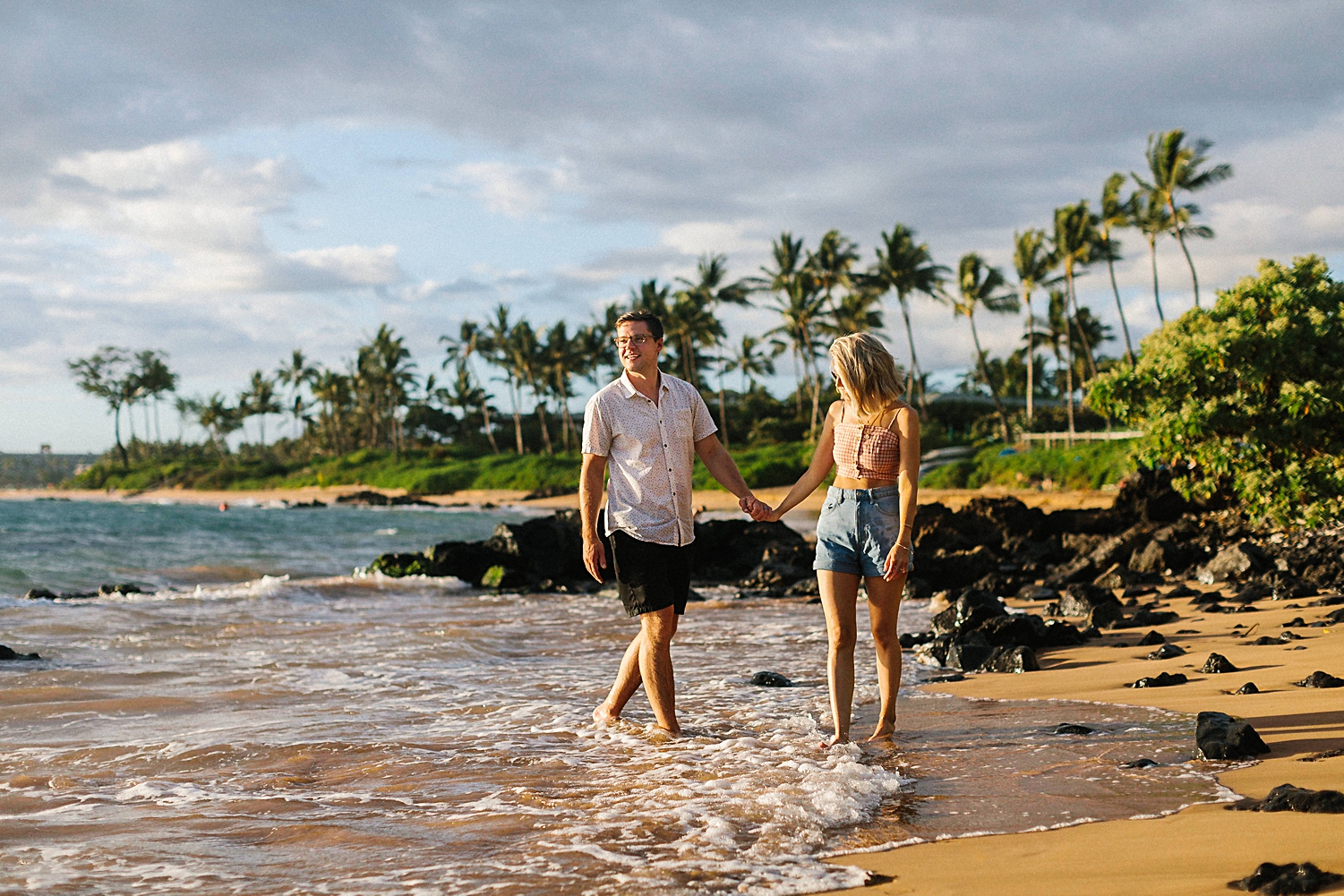 Couple walking on wailea beach Maui Hawaii palm trees