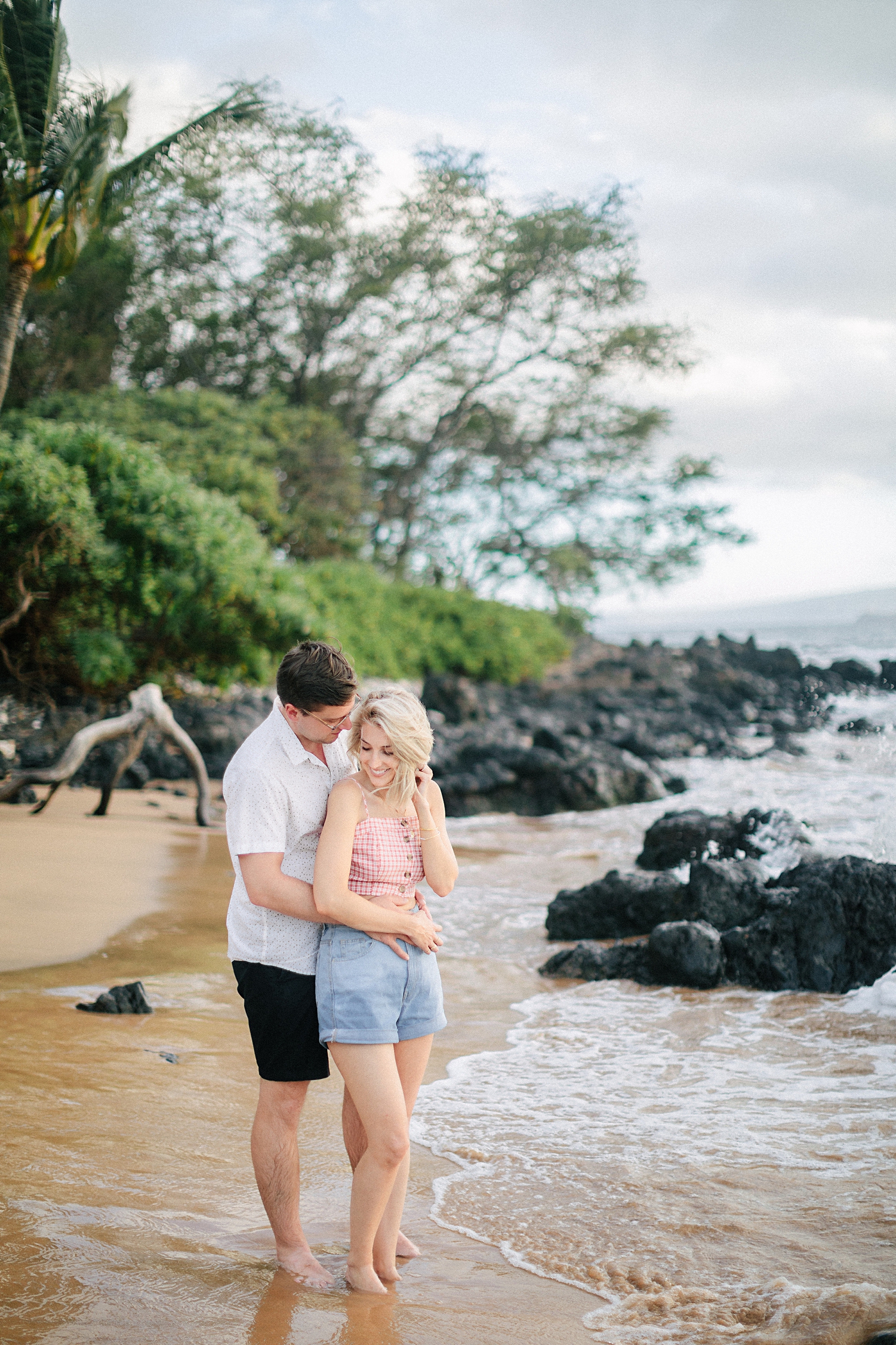 man with arms around woman on beach in Maui hawaii