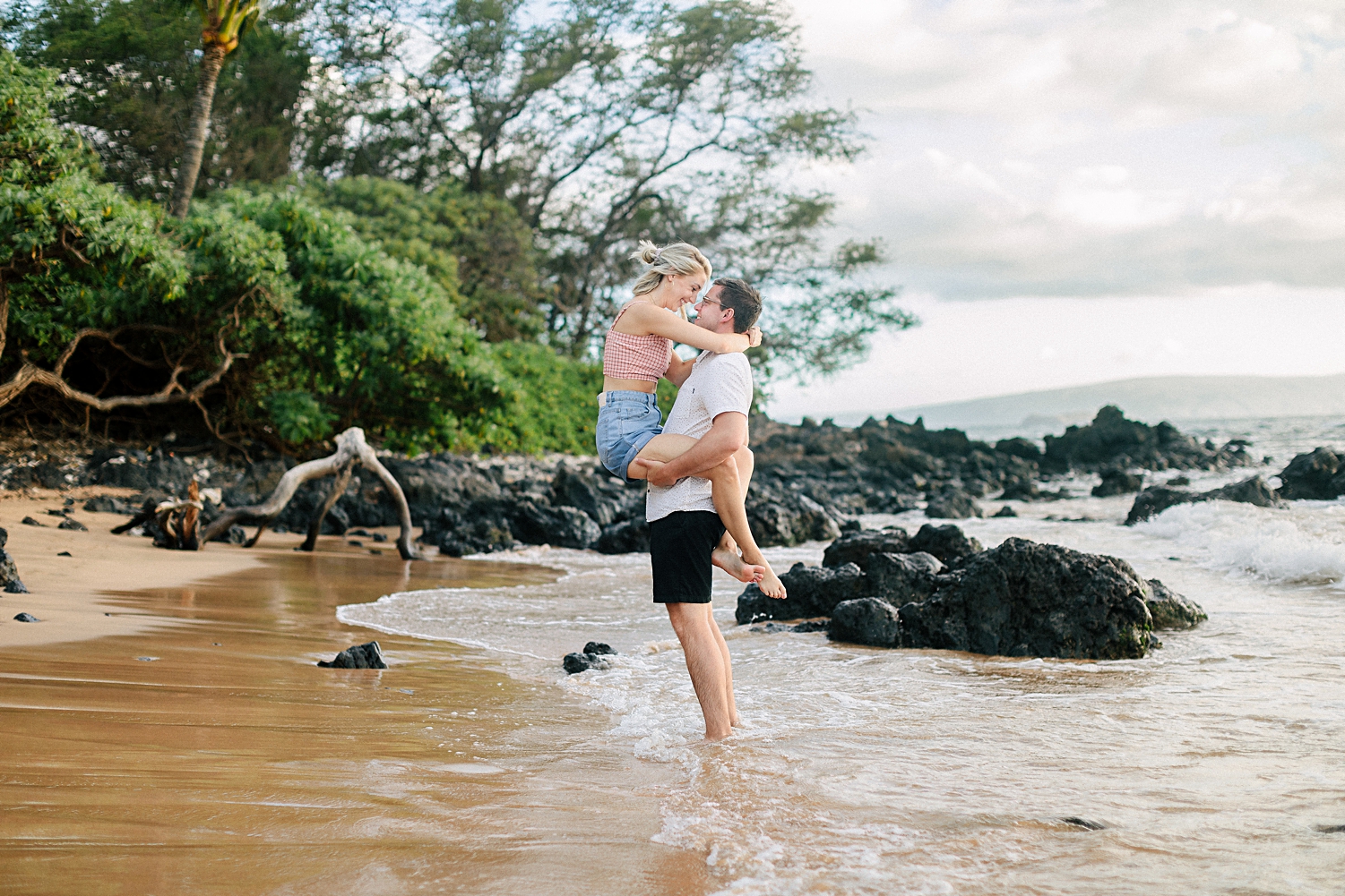 man holding girl in arms on wailea beach maui