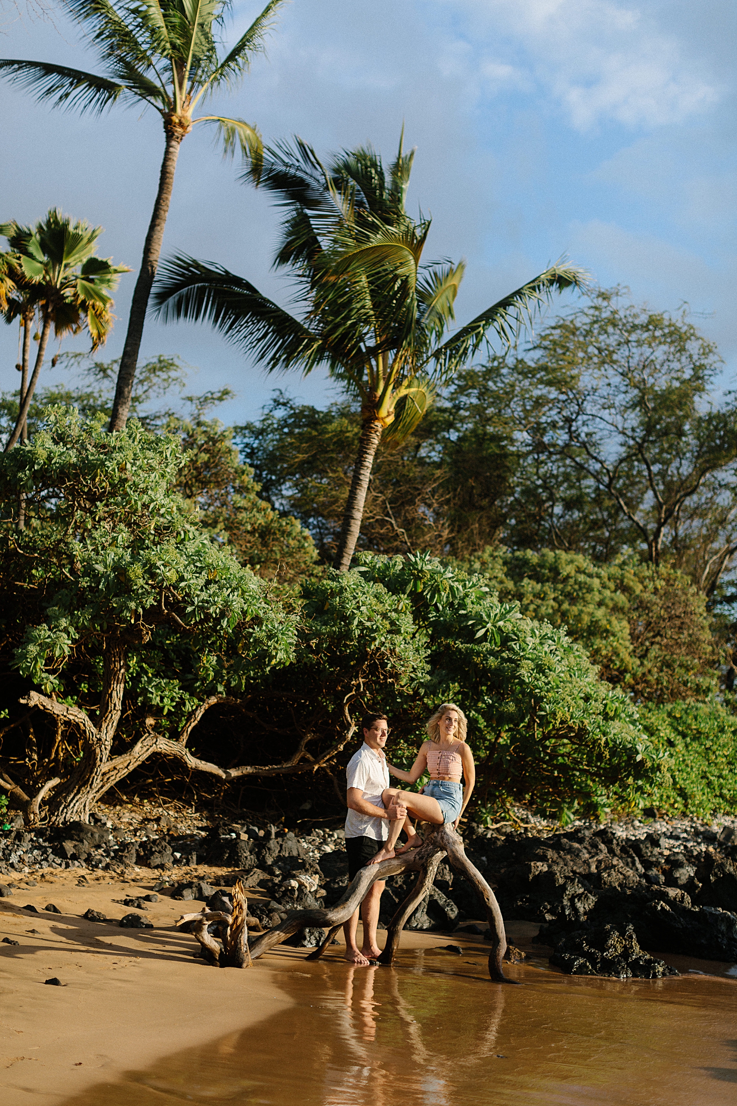 couple sitting on branch wailea beach in hawaii