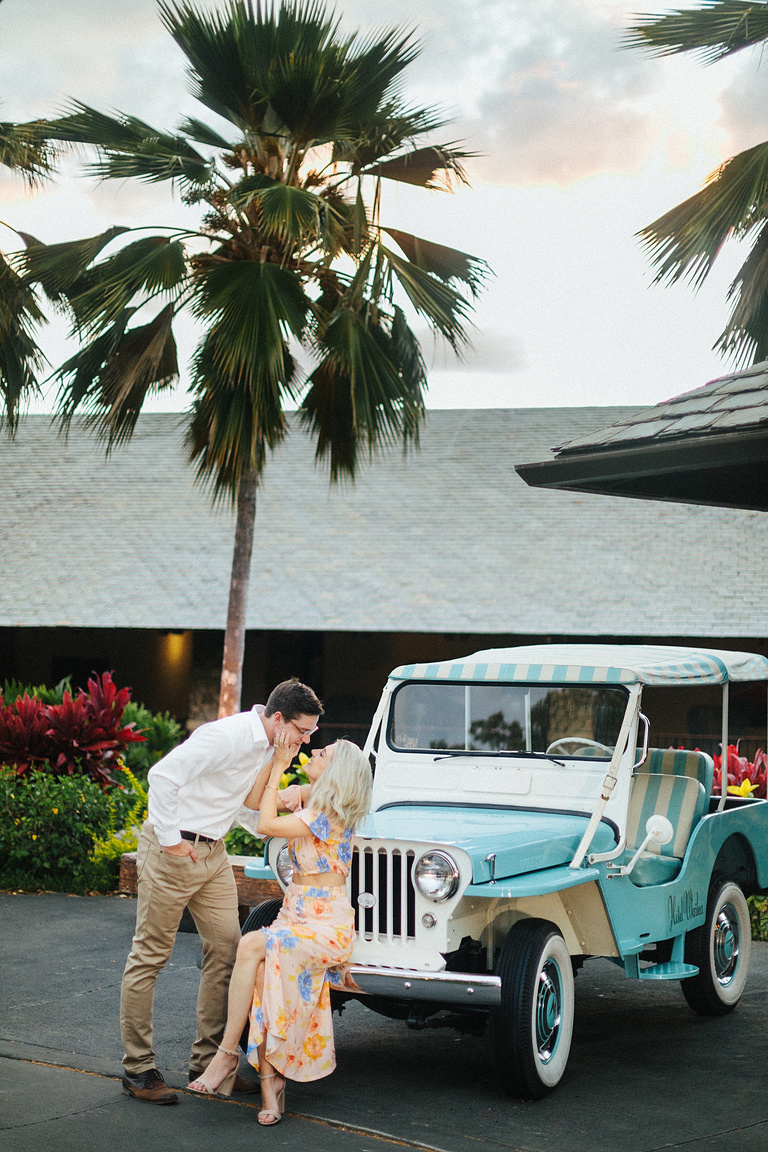 husband kissing wife by vintage Jeep at Hotel Wailea in Maui Hawaii