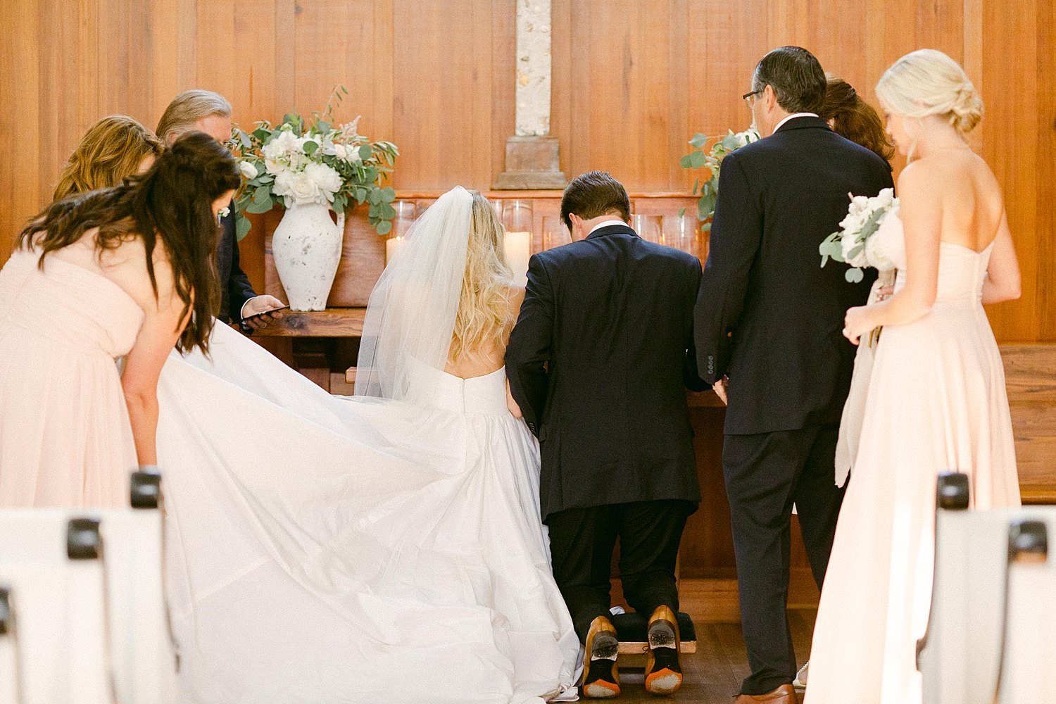 bride and groom kneeling in prayer at wedding altar Seaside chapel Florida