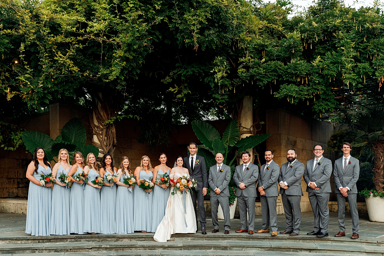 colorful wedding bride, groom, and wedding party at dallas arboretum