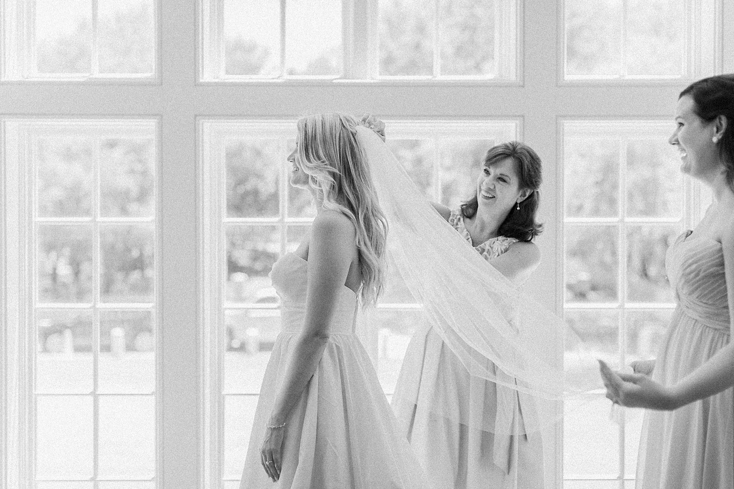 mother helping Bride in wedding dress and veil getting ready at Seaside Chapel in Florida