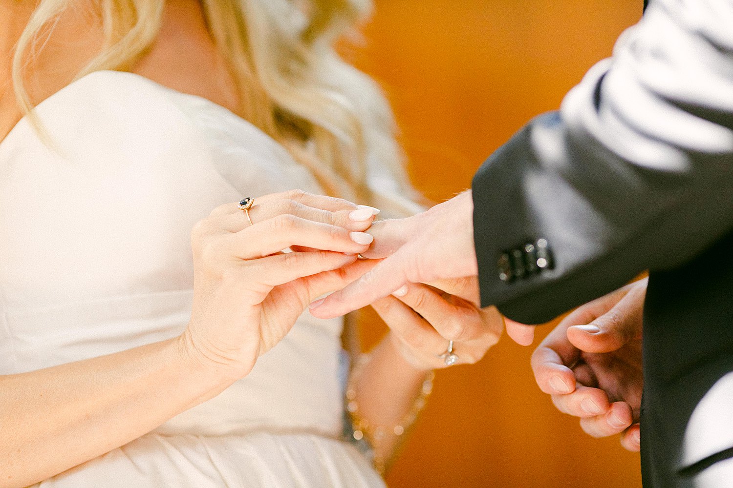 bride putting ring on grooms hand at wedding