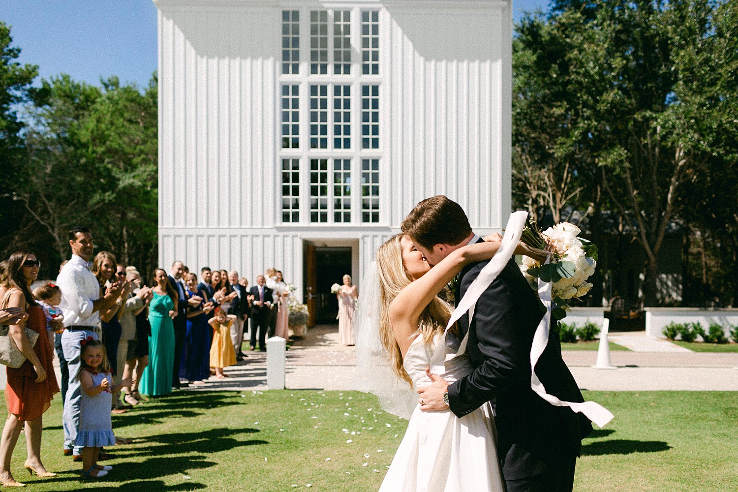 bride and groom kissing outside white Seaside chapel Florida