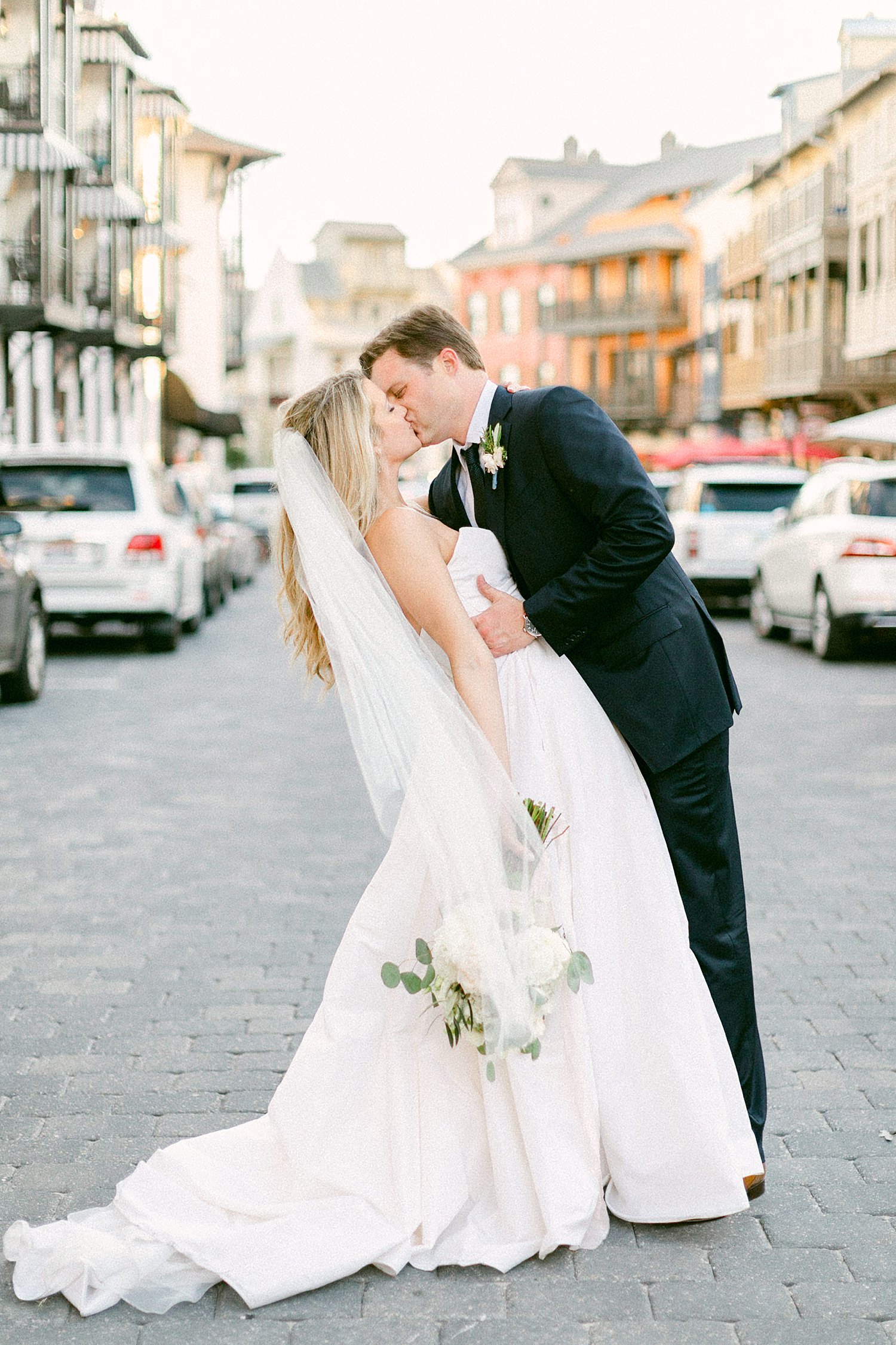 Bride holding bouquet kissing groom on wedding day at the Pearl Hotel in Rosemary Beach Florida