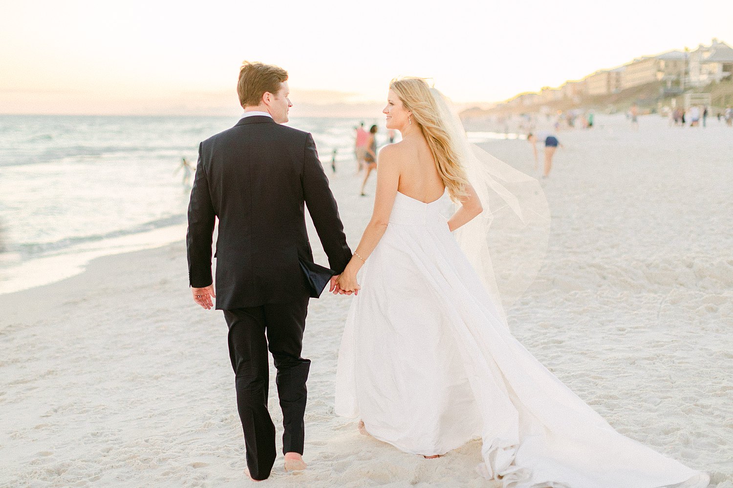 Bride and groom walking away barefoot on rosemary beach wedding day at the Pearl Hotel in Florida