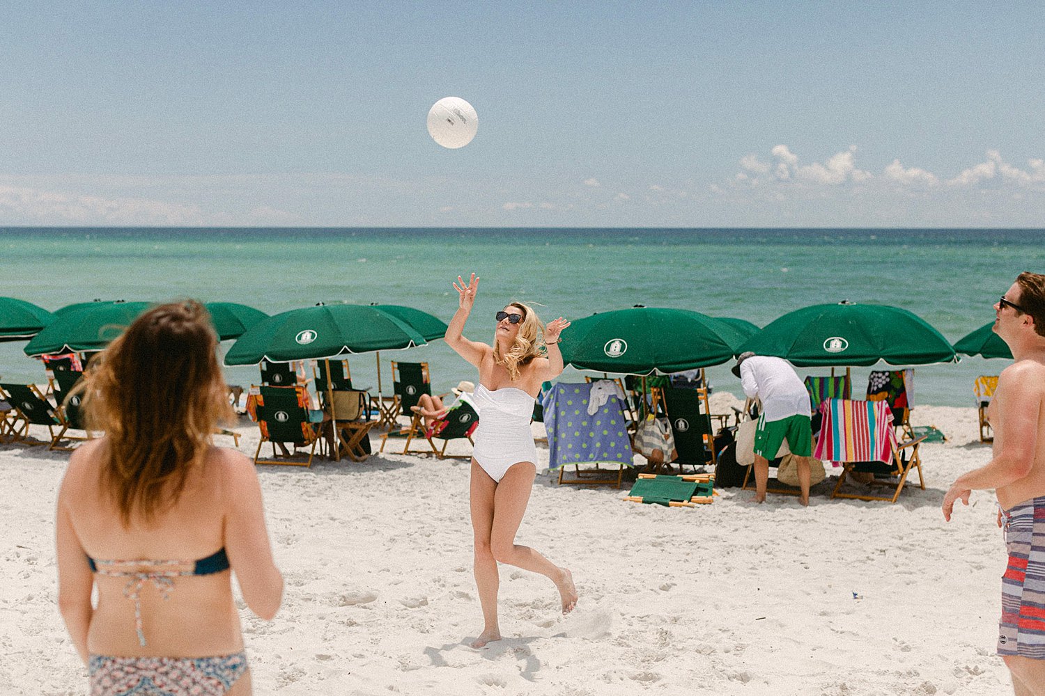 woman in white bathing suit playing volleyball on Florida beach