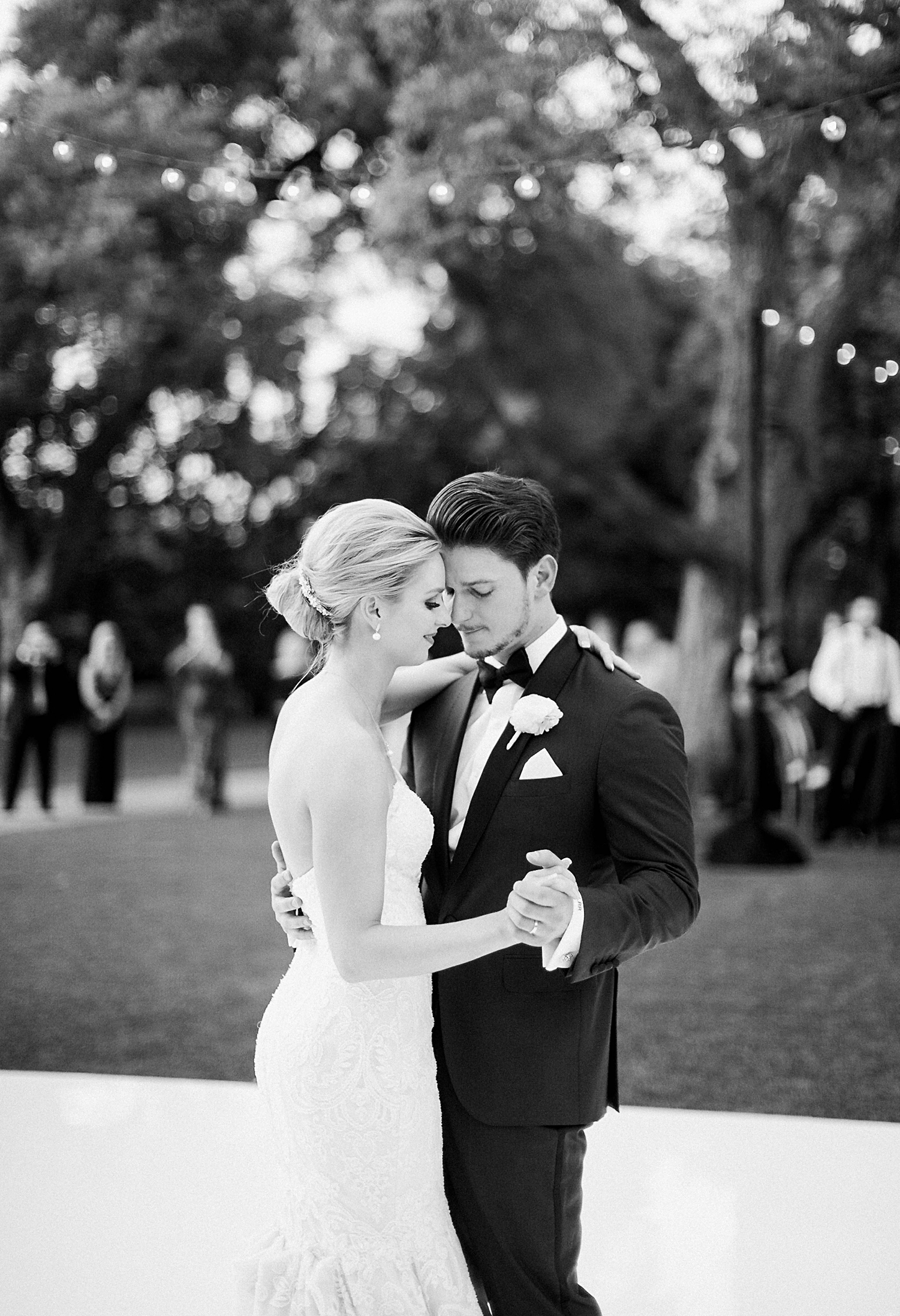Bride and groom dancing on white outdoor dance floor Dallas Arboretum wedding garden reception black and white