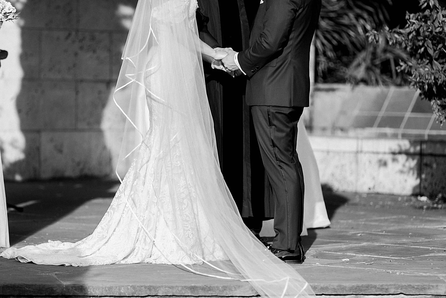 Bride and groom holding hands at ceremony altar Dallas Arboretum wedding black and white
