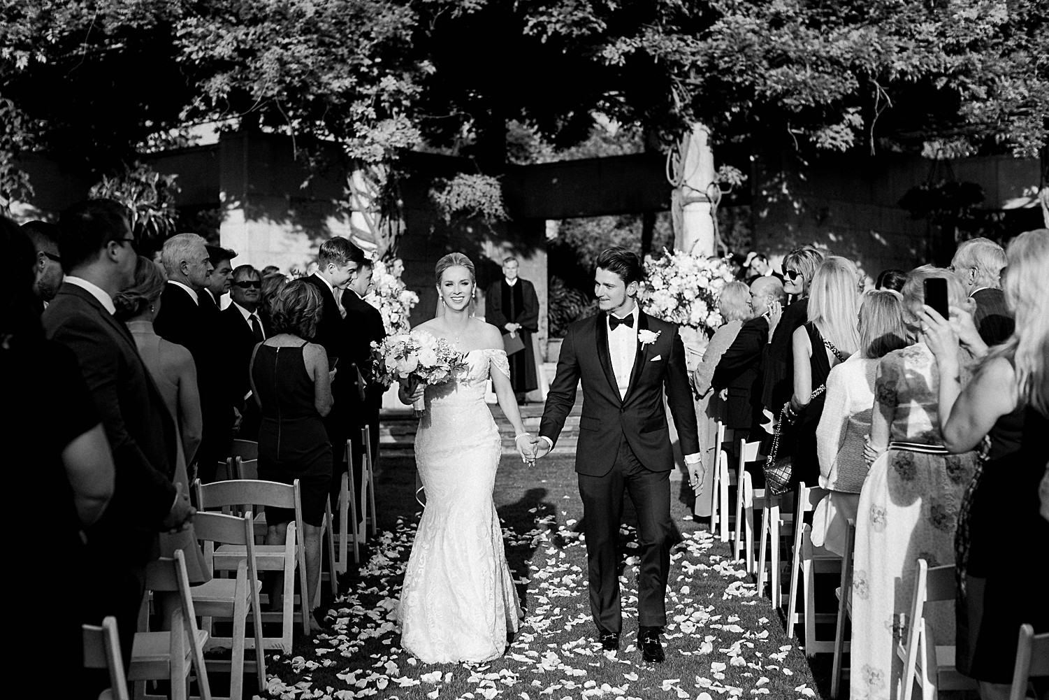Bride and groom recessional laughing at ceremony altar Dallas Arboretum wedding black and white