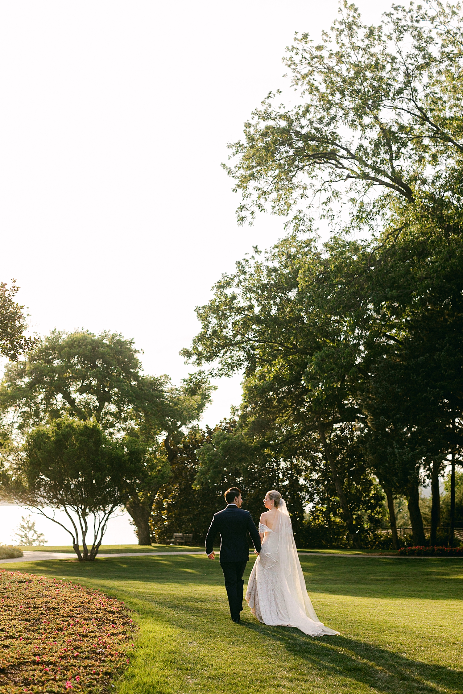 Bride and groom recessional Dallas white rock lake Arboretum wedding sunset