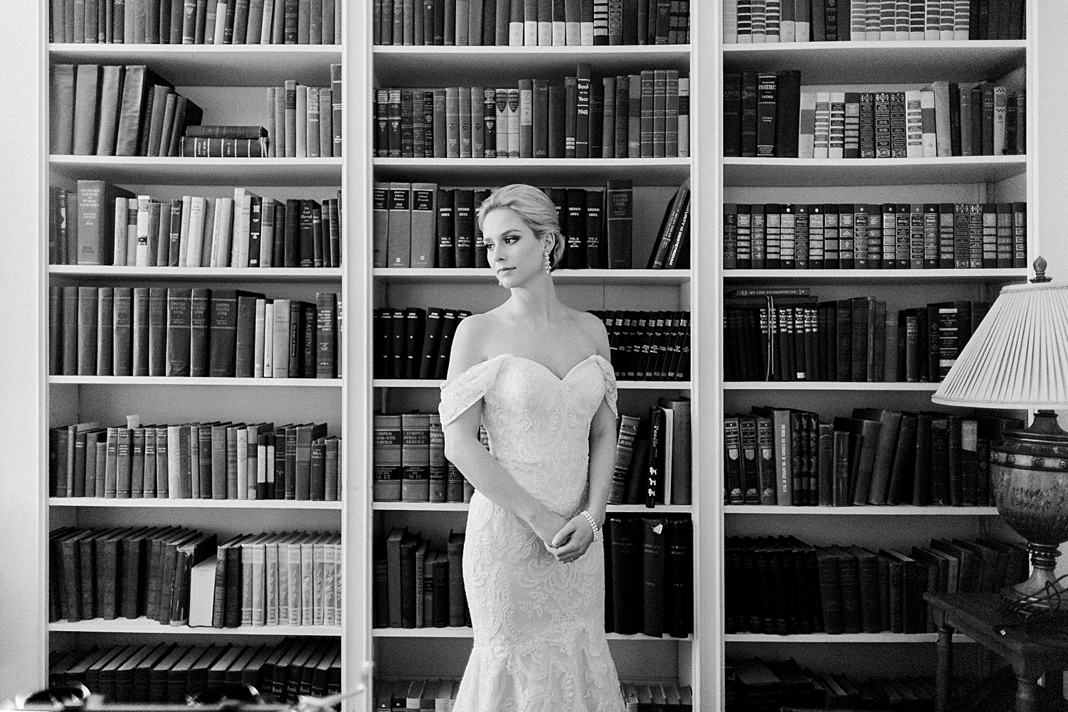 Bride standing in front of large bookcase classic Wedding bridal session