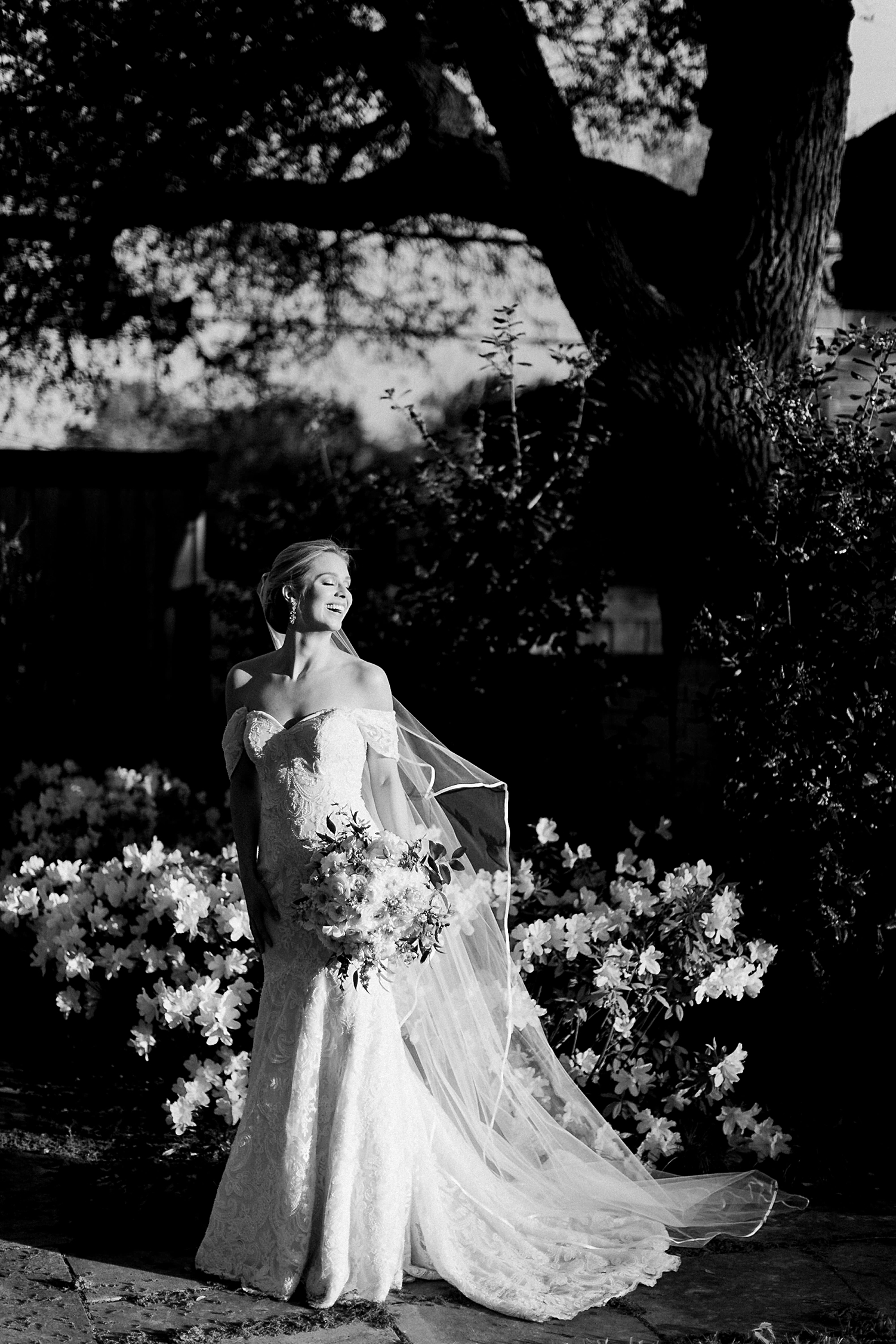 bridal session in garden bride in wedding dress and veil holding white bouquet