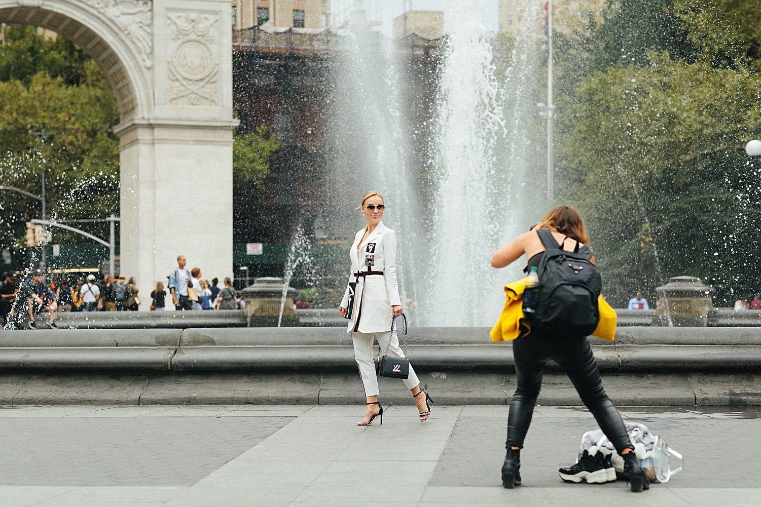 Social media blogger having photo taken in washington square park fountain new york city