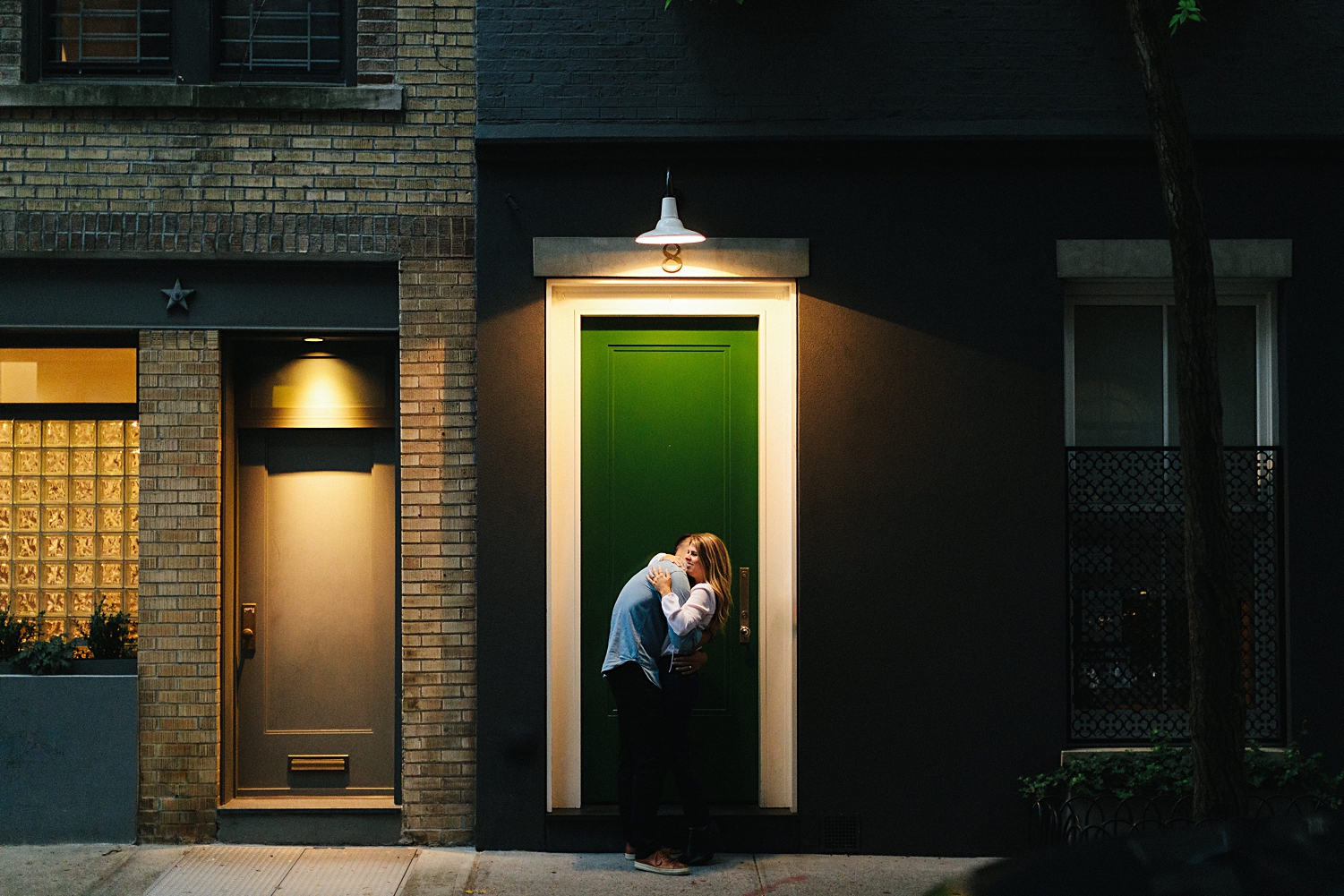 Man and woman embracing under street light green door sidewalk
