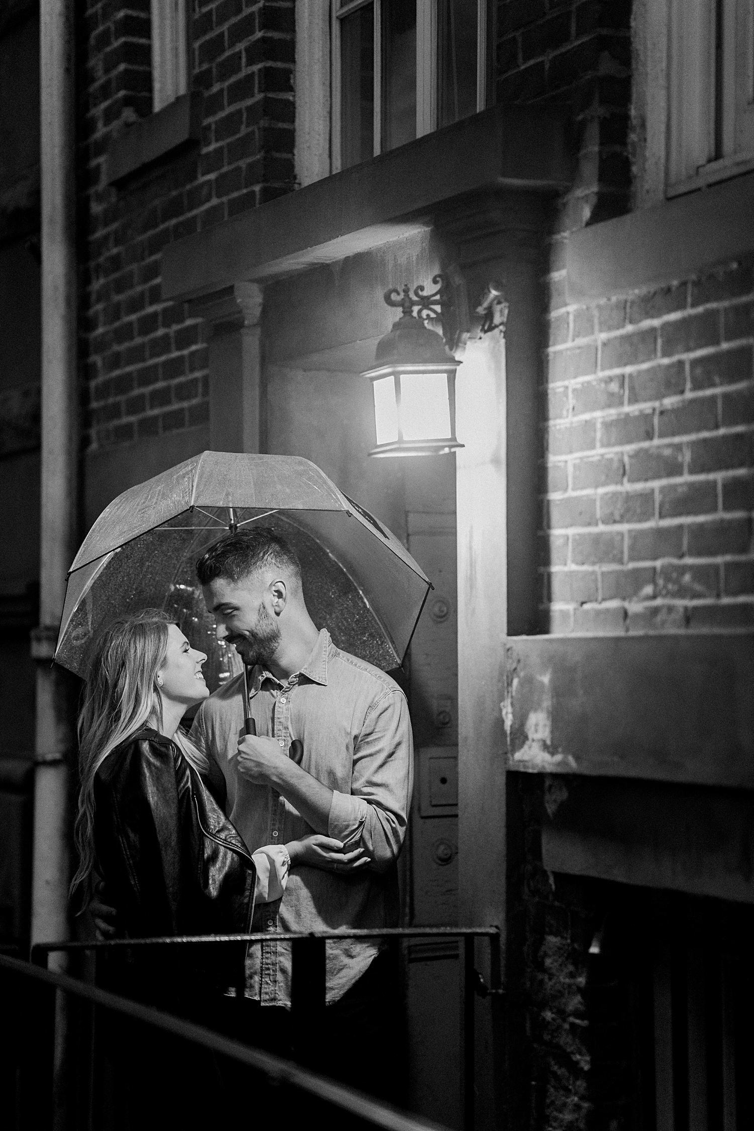 man and woman embracing holding umbrella under street light new york Greenwich Village Engagement