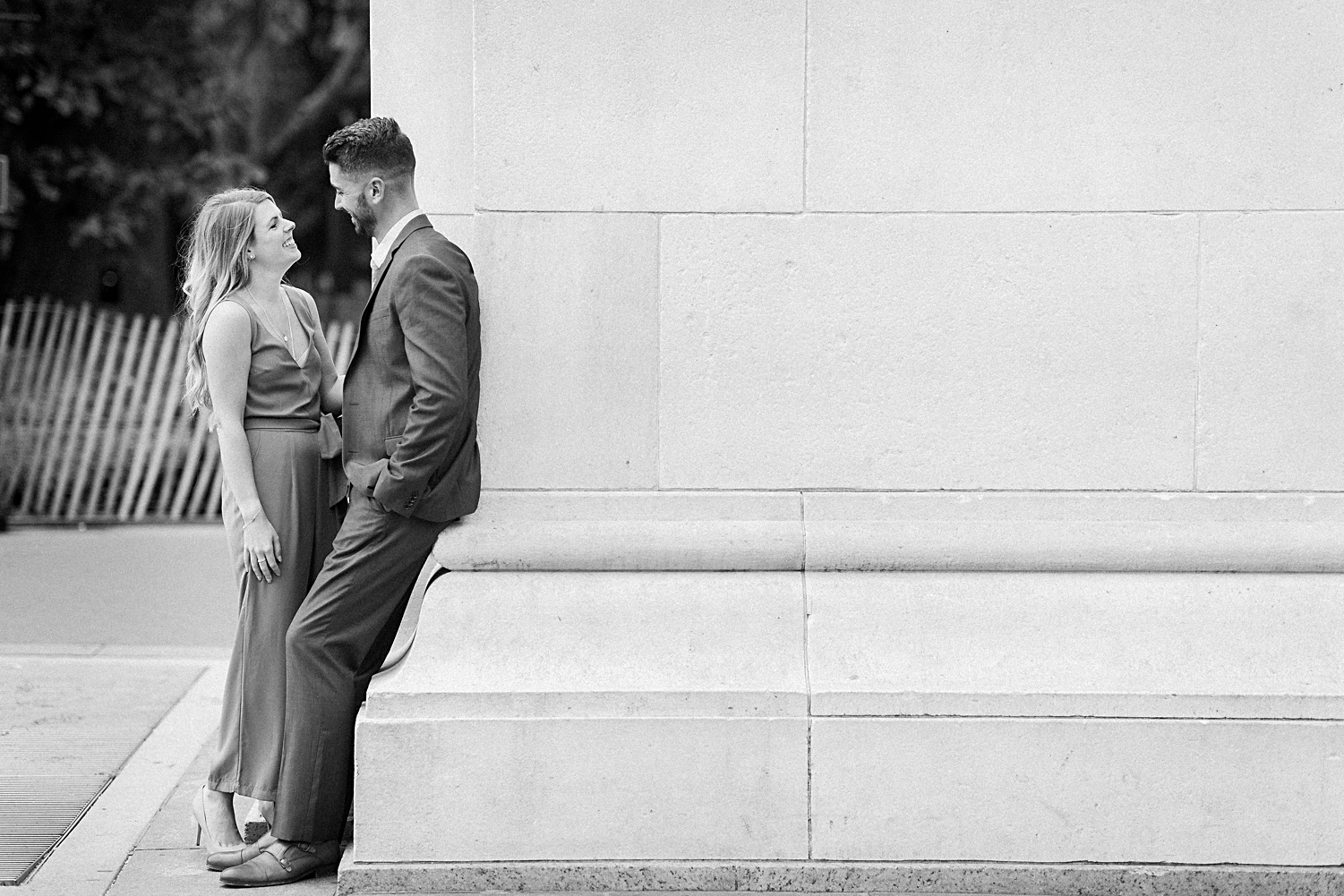 couple leaning on concrete monument in park