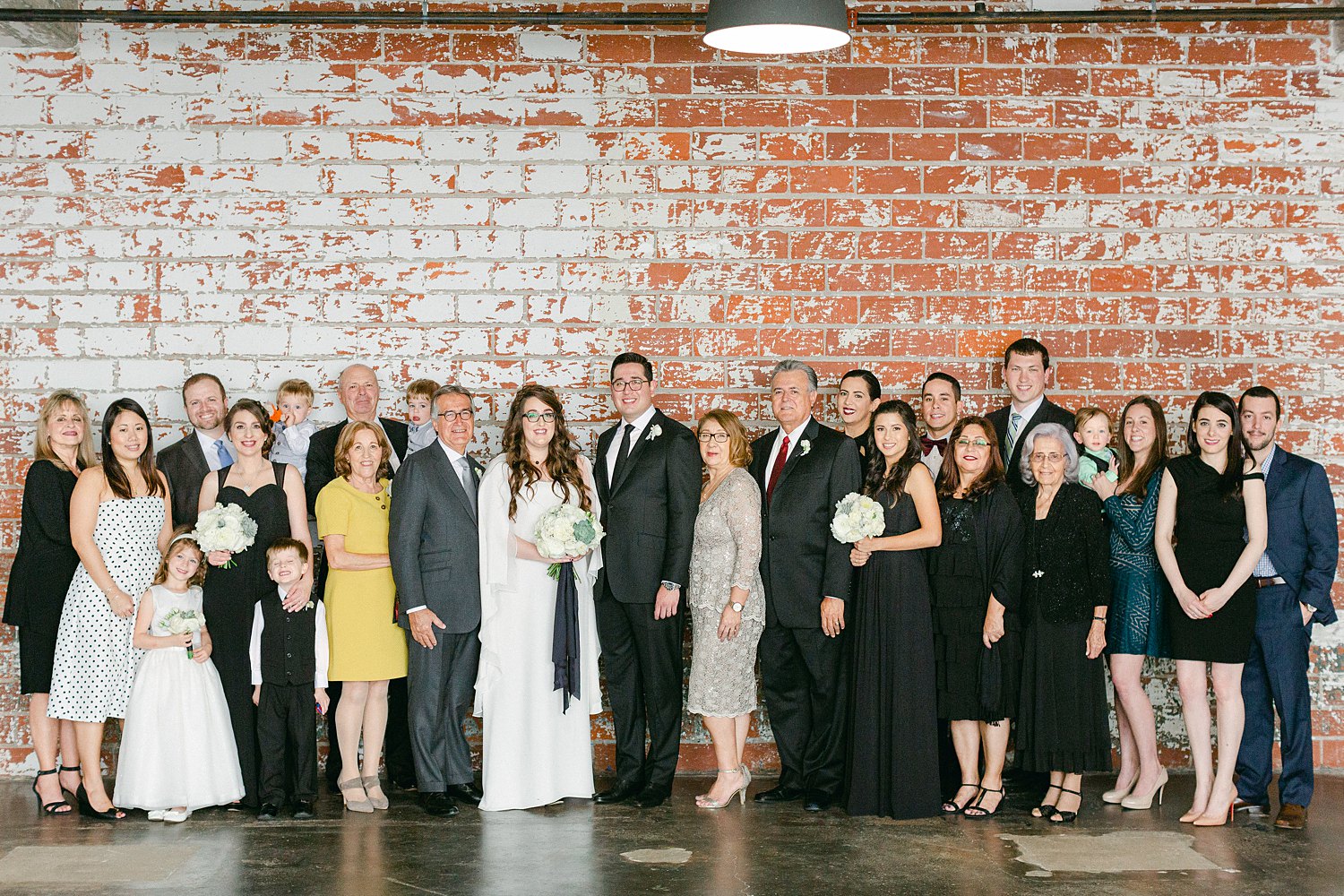 Intimate Houston Wedding day family group shot against brick wall