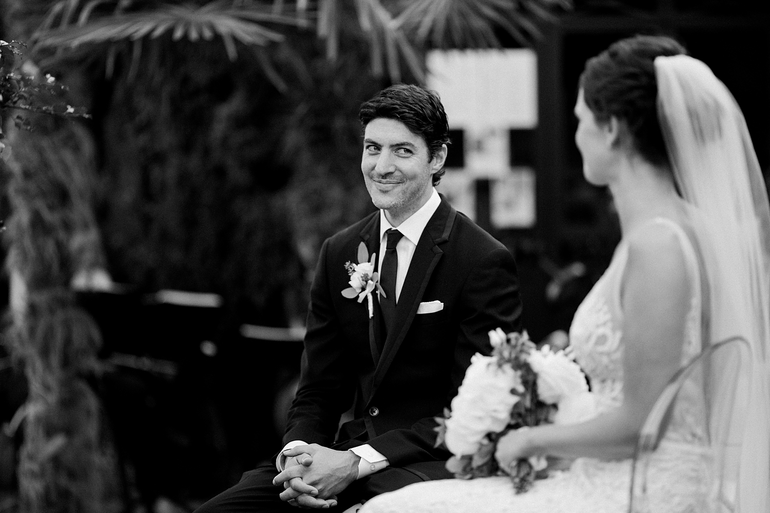 groom in tuxedo sitting at Italian wedding ceremony black and white