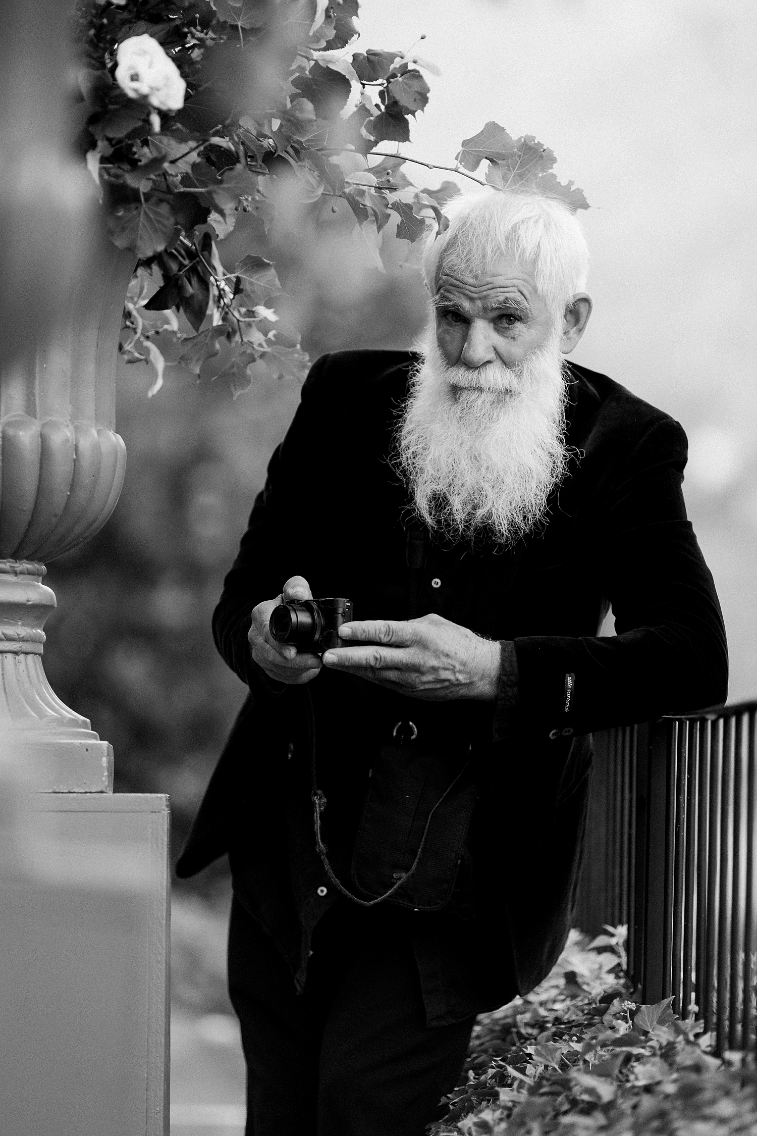old man in black suite holding camera portrait Italy black and white