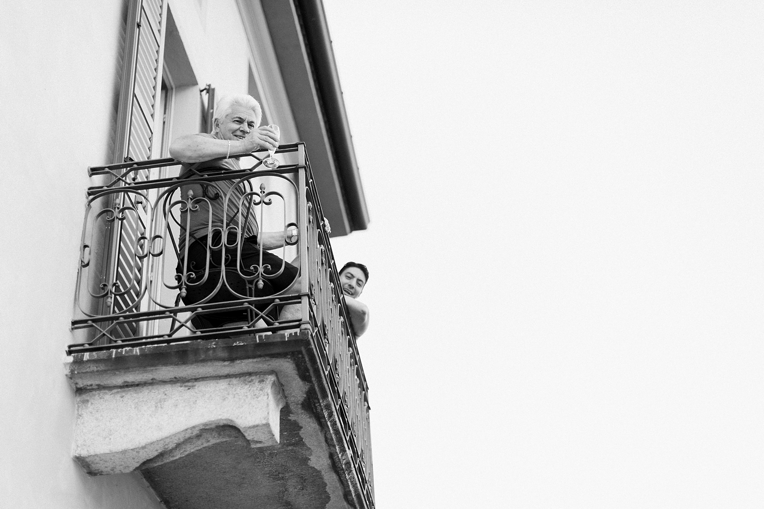 two men sitting on balcony black and white