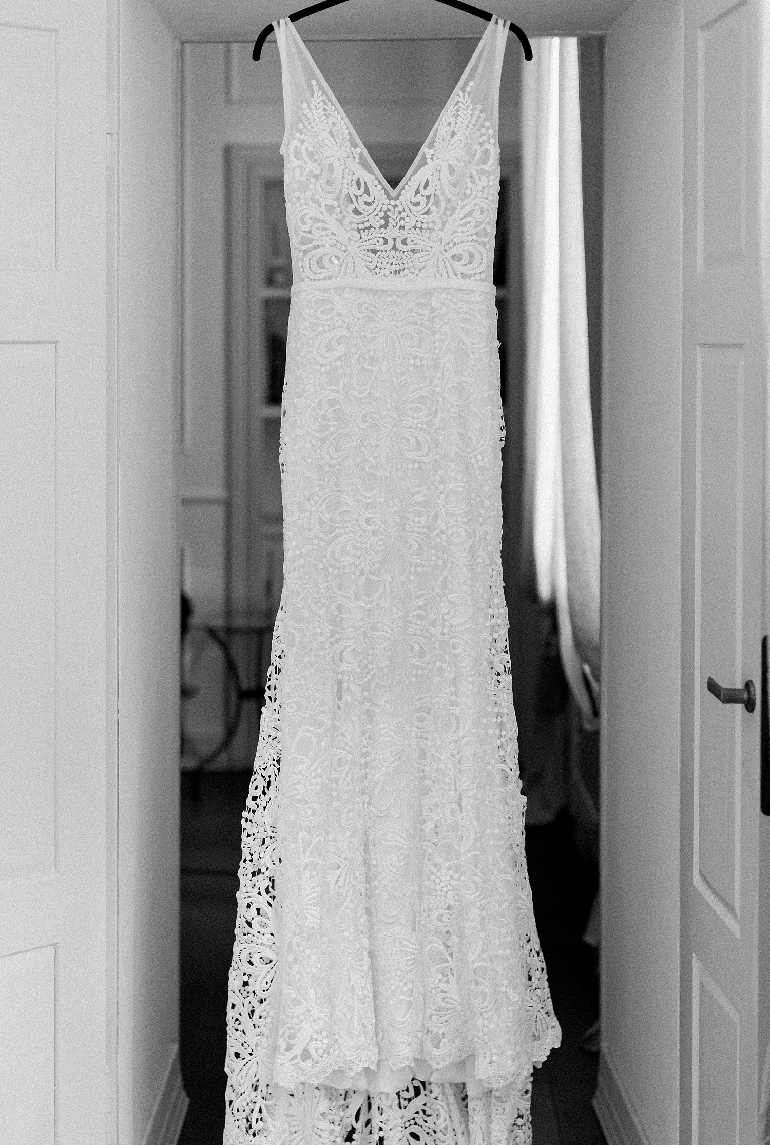black and white wedding dress hanging in doorway lace