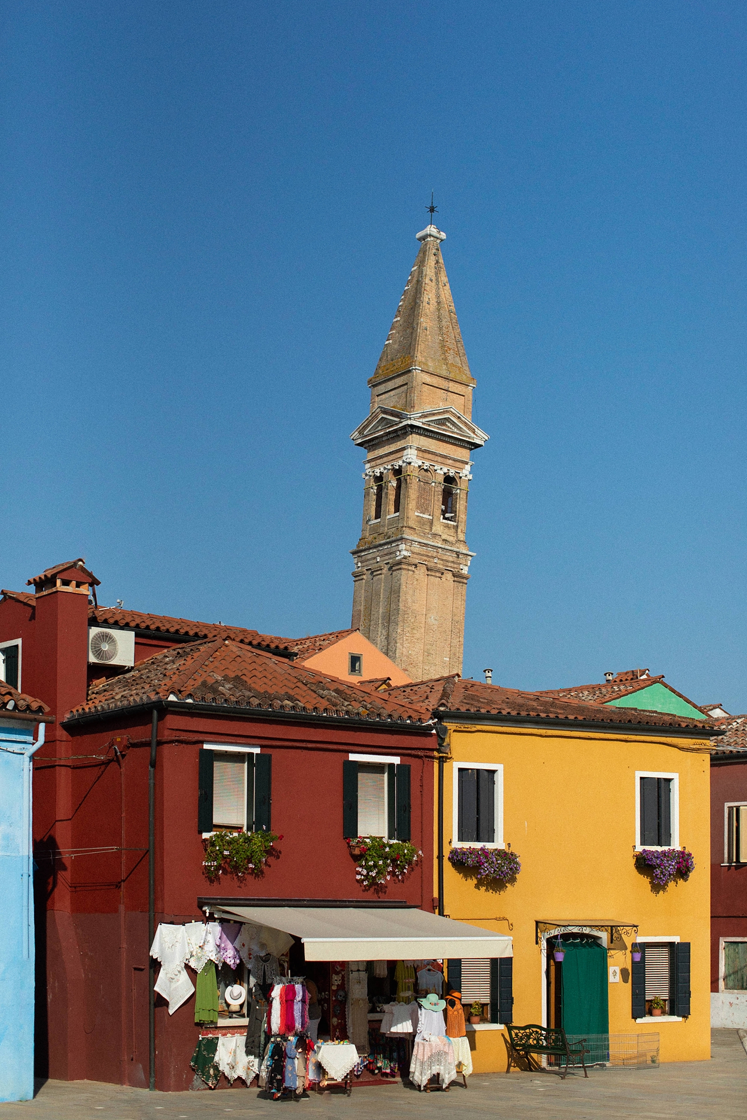 red, yellow, and blue buildings clock tower in Burano Italy