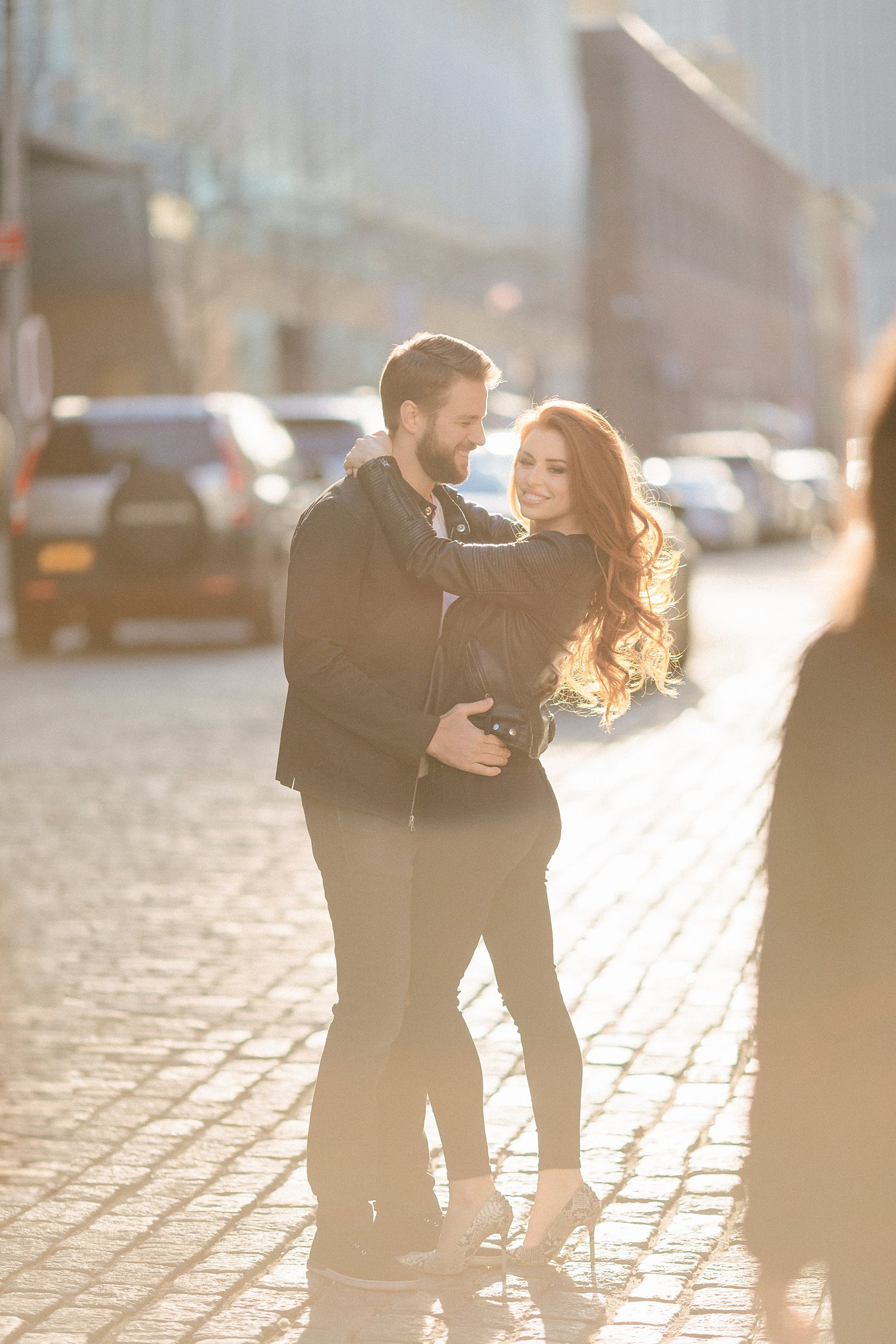 Couple embracing on NYC street at sunset during Brooklyn engagement