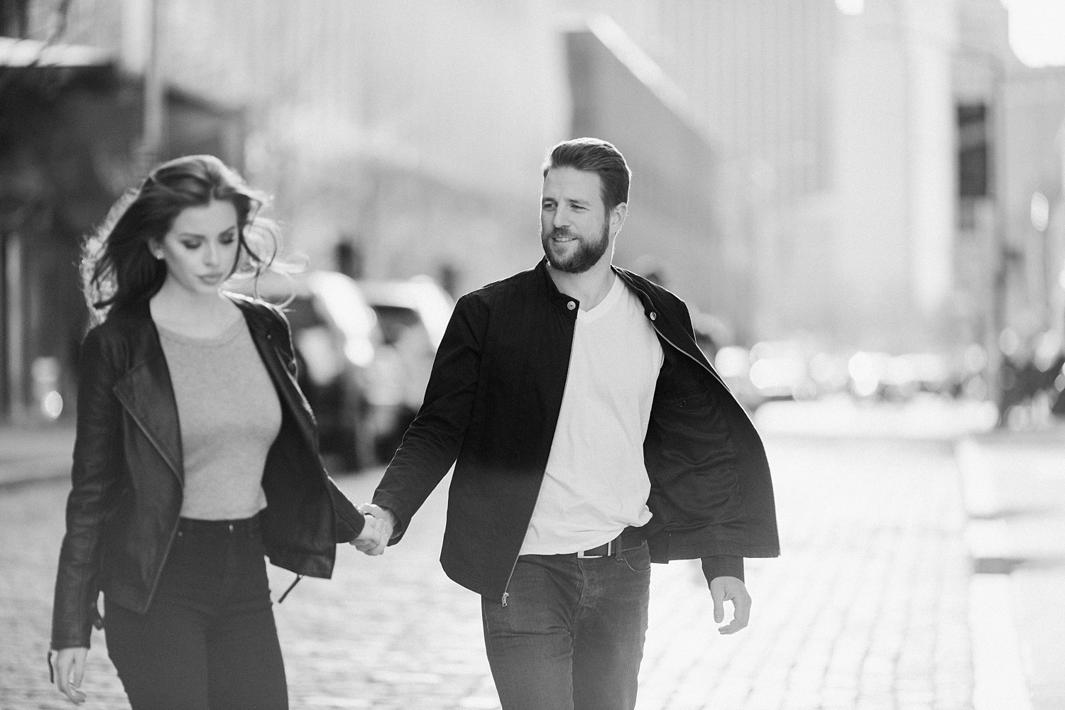 couple walking holding hands on brooklyn street engagement black white
