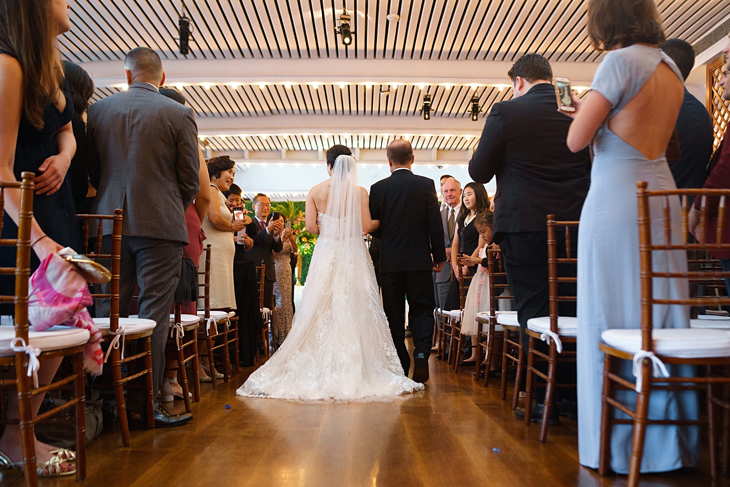 bride and father walking down aisle seen from behind at water club new york city