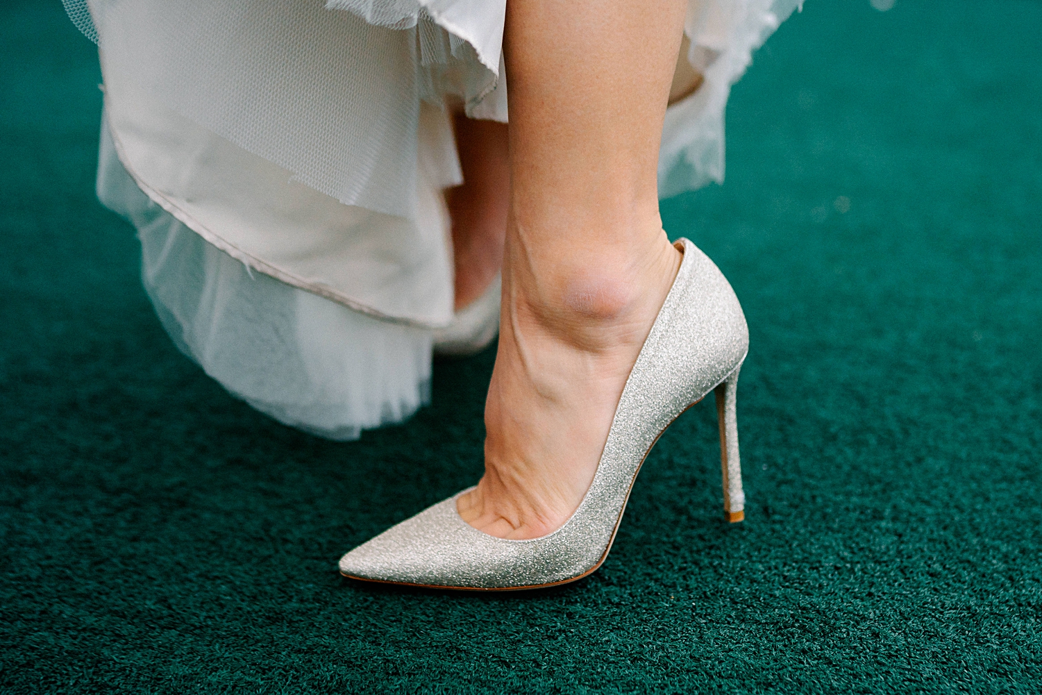 silver high heel glitter bridal shoe on green floor